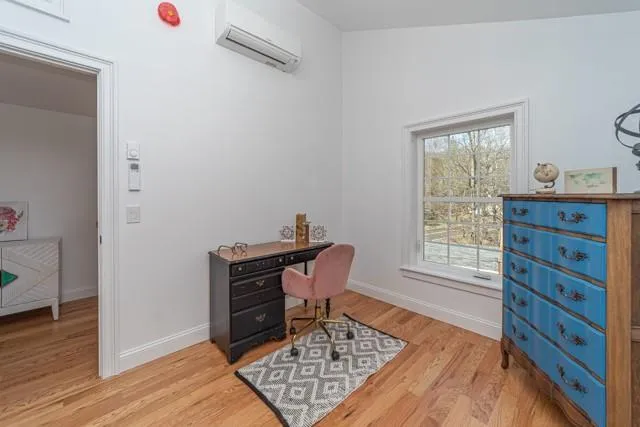Office area featuring an AC wall unit and light wood-style floors Office area featuring an AC wall unit and light wood-style floors