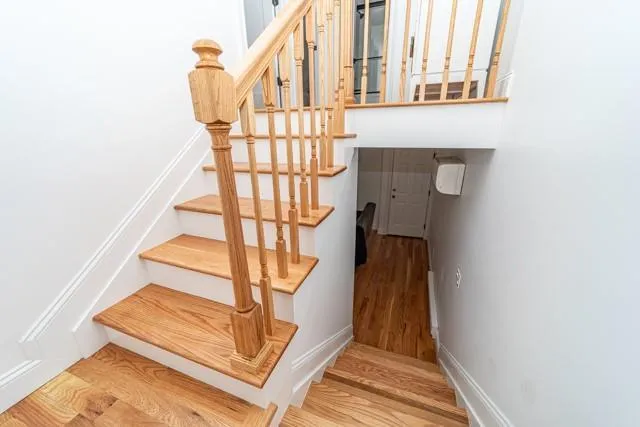 Stairway featuring wood finished floors and baseboards Stairway featuring wood finished floors and baseboards