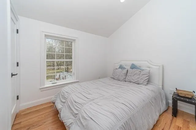 Bedroom with light wood-style flooring and vaulted ceiling Bedroom with light wood-style flooring and vaulted ceiling