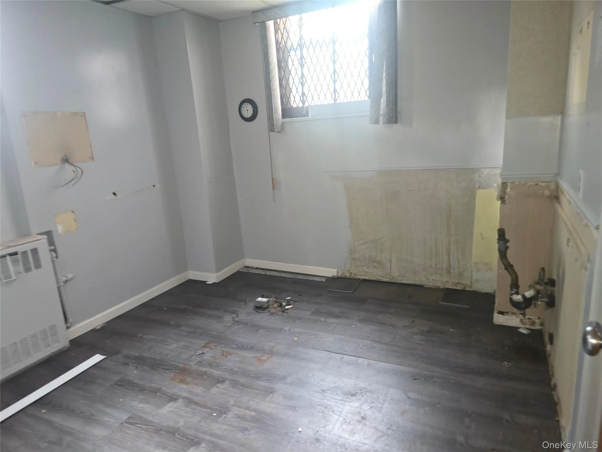 Empty room featuring radiator heating unit and wood finished floors Empty room featuring radiator heating unit and wood finished floors