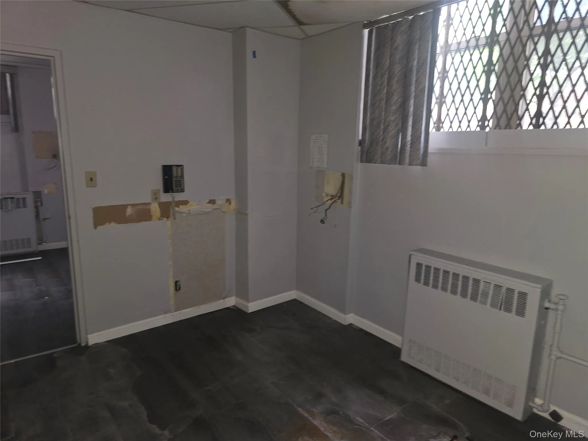 Unfurnished room with radiator and dark wood-style floors Unfurnished room with radiator and dark wood-style floors