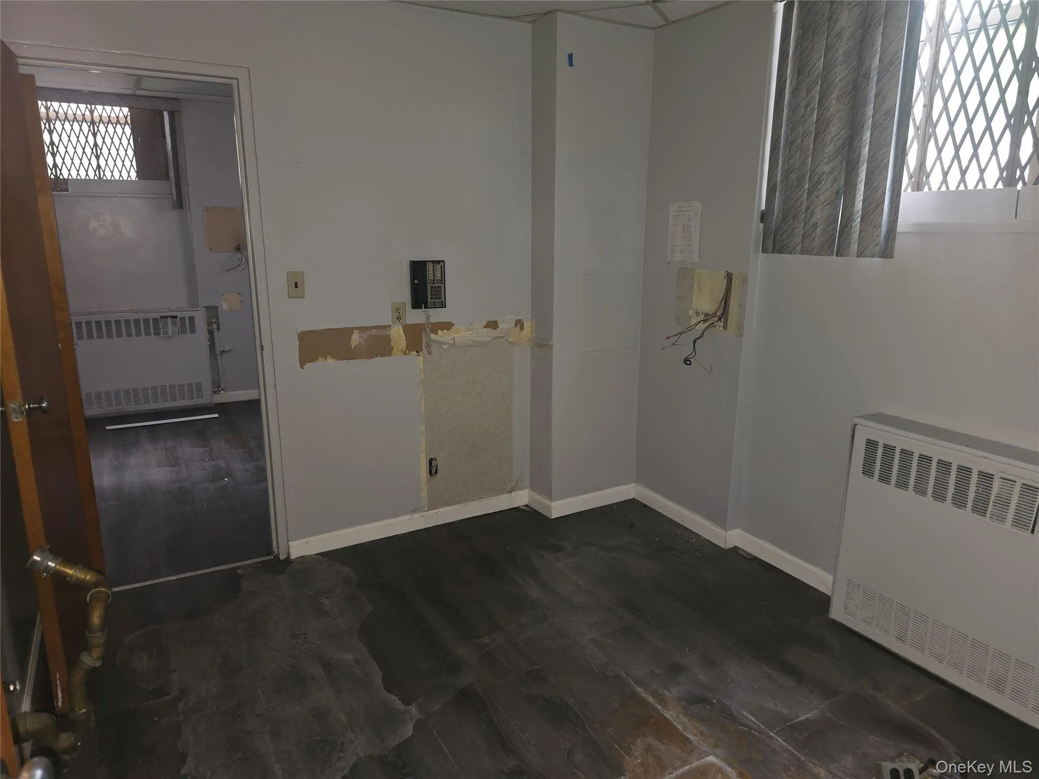 Laundry room with radiator and dark wood-type flooring Laundry room with radiator and dark wood-type flooring