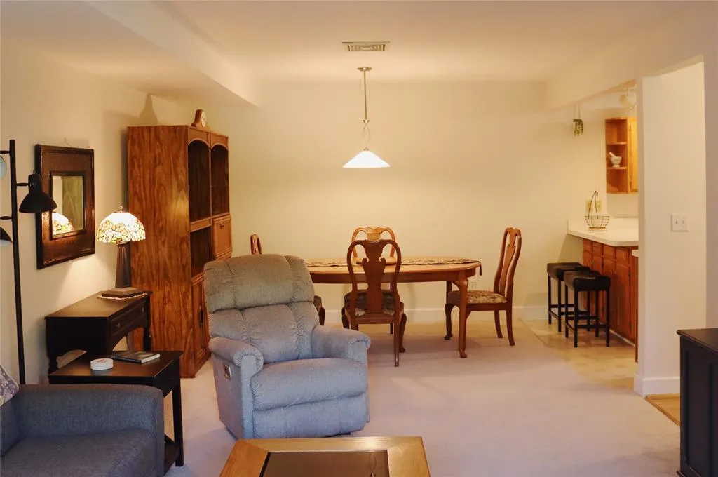 Living area featuring light carpet and baseboards Living area featuring light carpet and baseboards