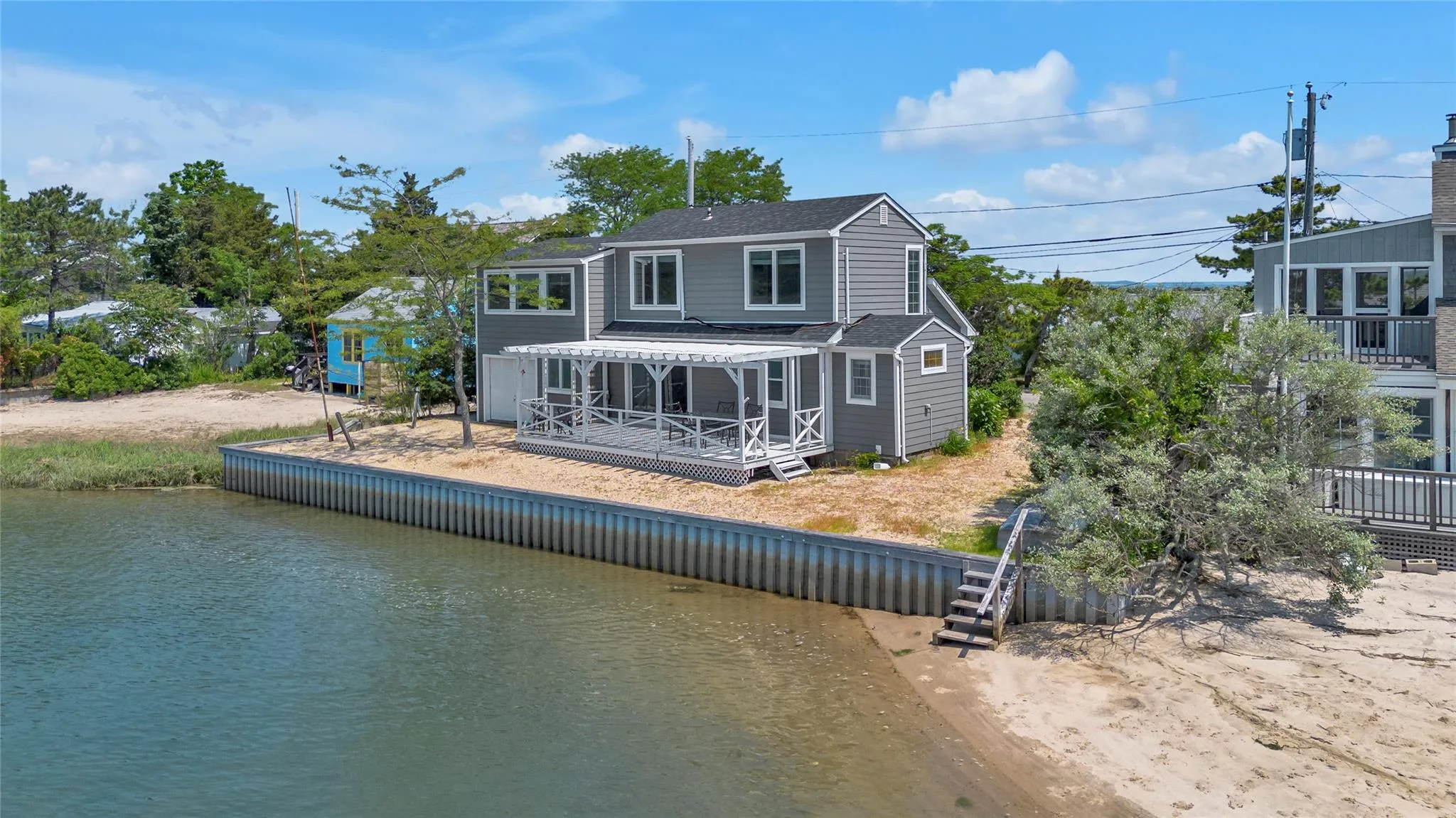 Back of property with a shingled roof and a deck with water view Back of property with a shingled roof and a deck with water view