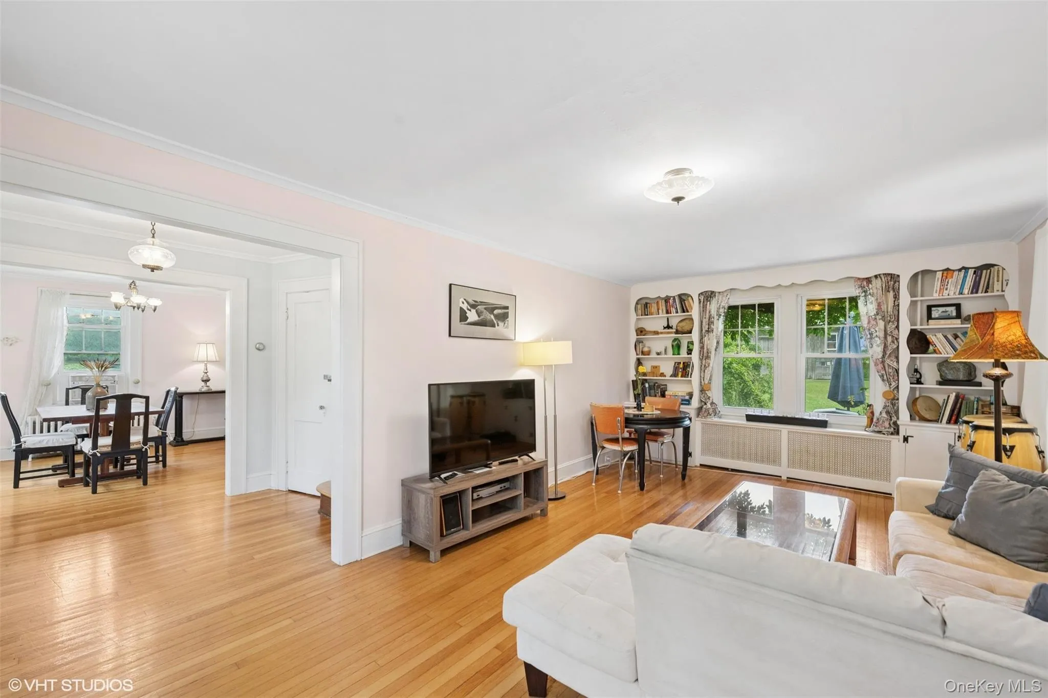 Living area with light wood-style flooring, a chandelier, and crown molding Living area with light wood-style flooring, a chandelier, and crown molding
