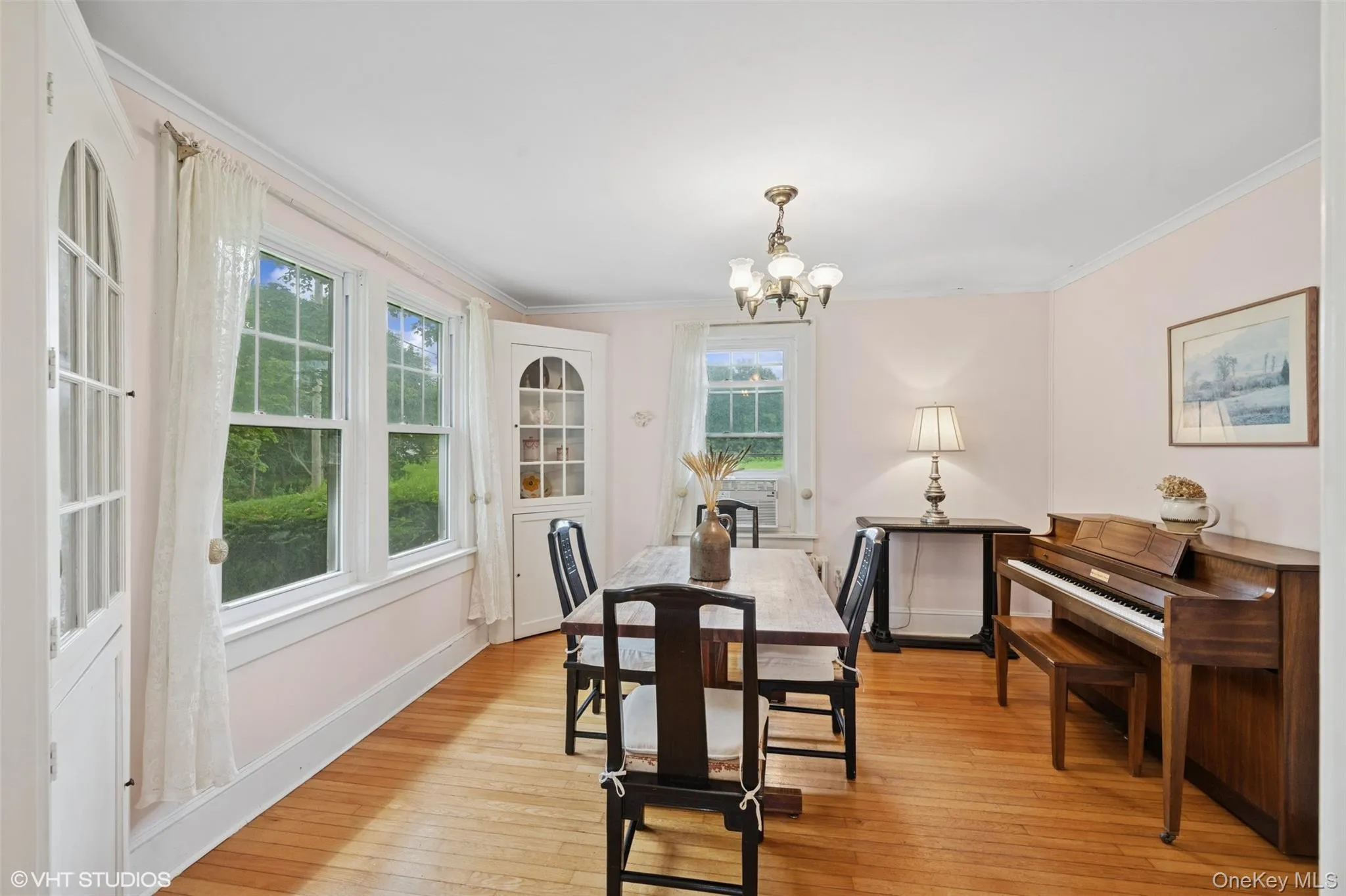 Dining room with a chandelier, ornamental molding, plenty of natural light, and light wood finished floors Dining room with a chandelier, ornamental molding, plenty of natural light, and light wood finished floors