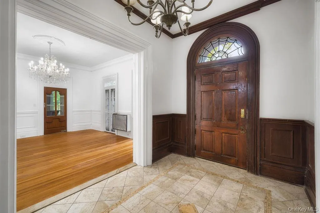 Entryway featuring a chandelier, crown molding, wainscoting. Entryway featuring a chandelier, crown molding, wainscoting.