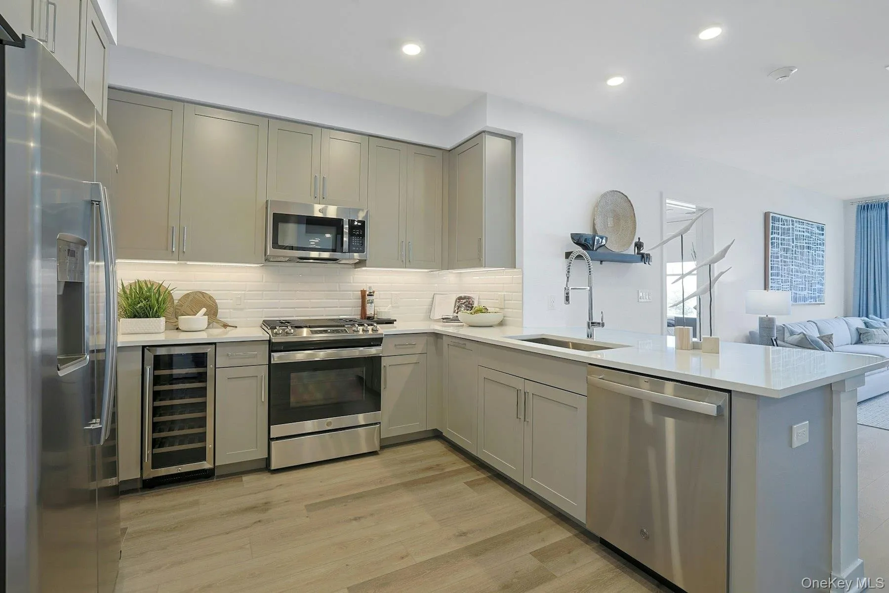 Open concept Kitchen with stainless steel appliances, Quartz countertops, wine cooler, gray cabinets Open concept Kitchen with stainless steel appliances, Quartz countertops, wine cooler, gray cabinets