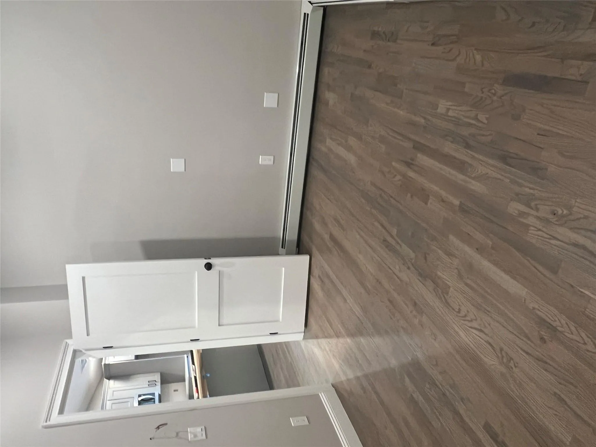 Empty room with baseboard heating and dark wood-style flooring Empty room with baseboard heating and dark wood-style flooring