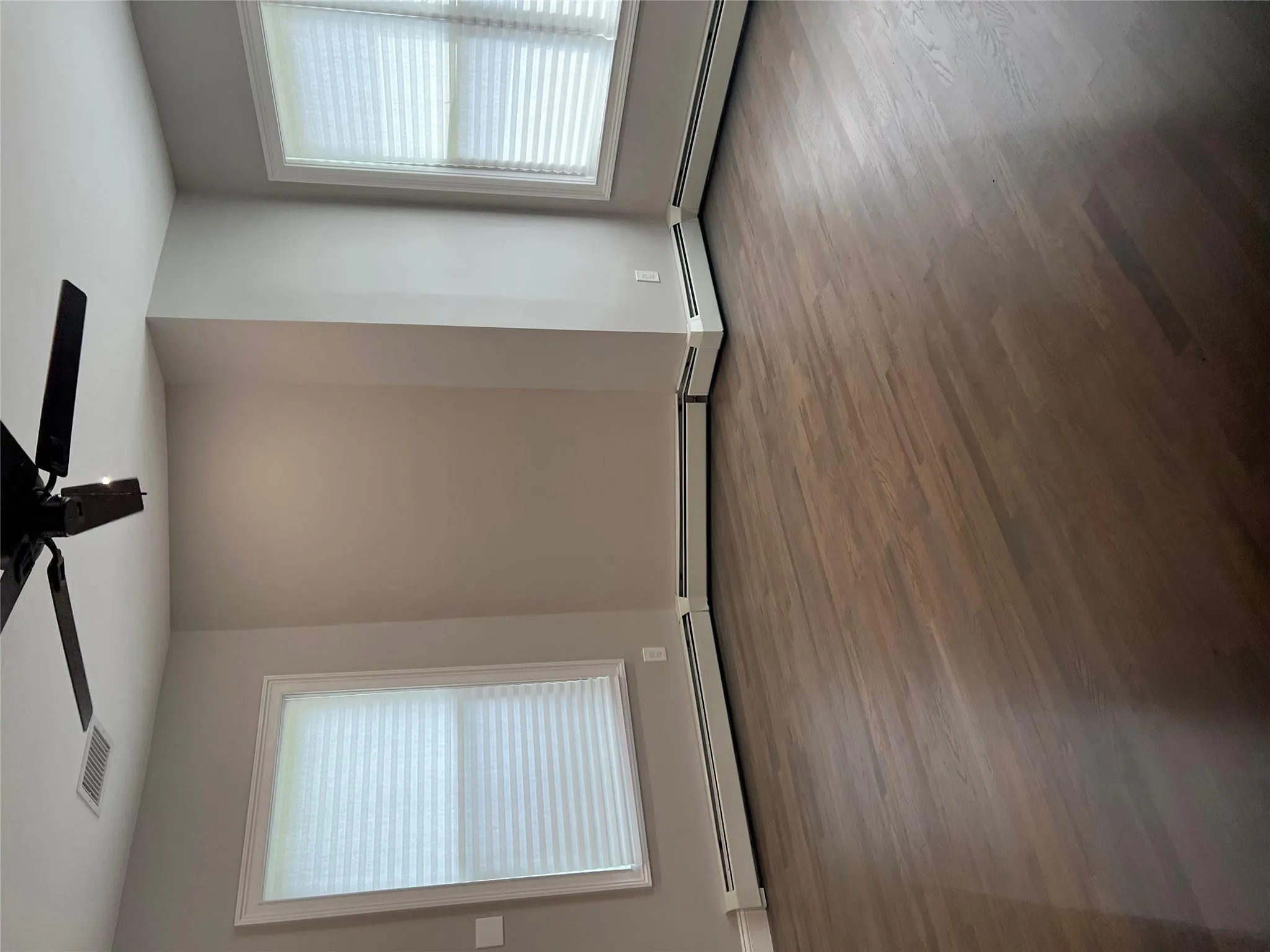 Unfurnished room featuring ceiling fan and dark wood-style floors Unfurnished room featuring ceiling fan and dark wood-style floors