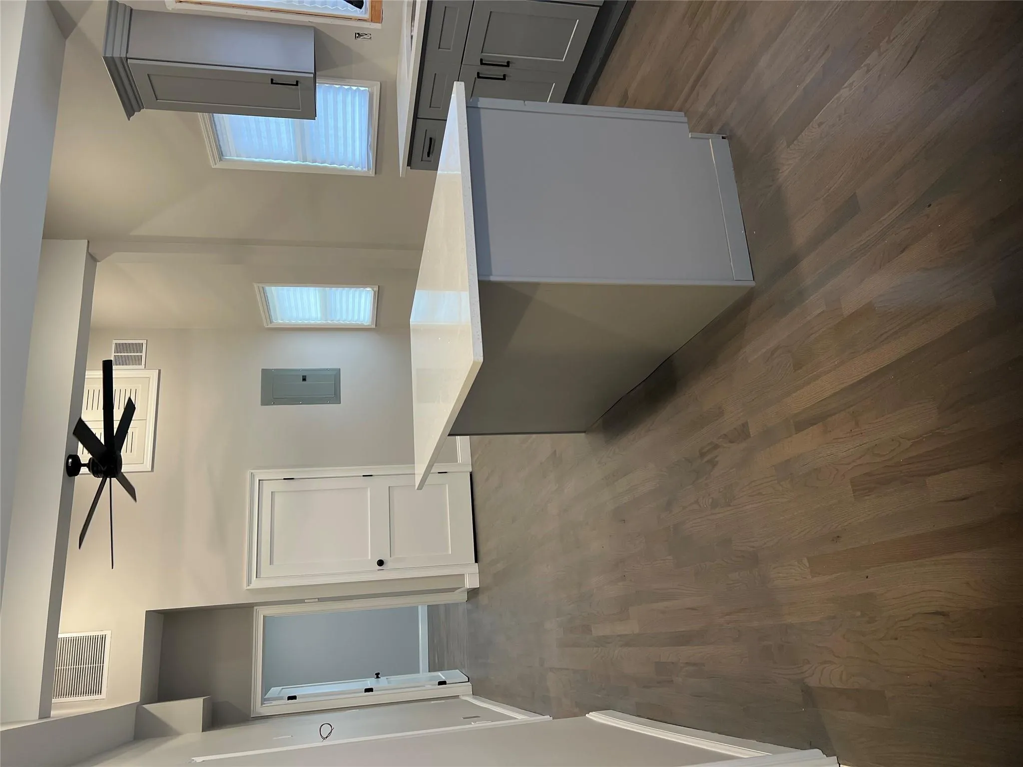 Kitchen featuring gray cabinetry, electric panel, a ceiling fan, and dark wood-type flooring Kitchen featuring gray cabinetry, electric panel, a ceiling fan, and dark wood-type flooring