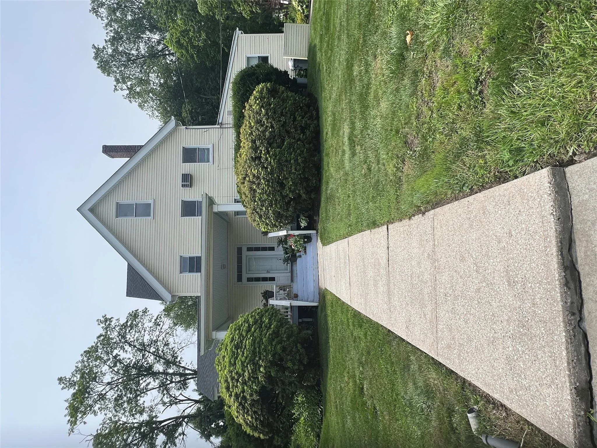 View of front of house with a porch, a front lawn, and a chimney View of front of house with a porch, a front lawn, and a chimney