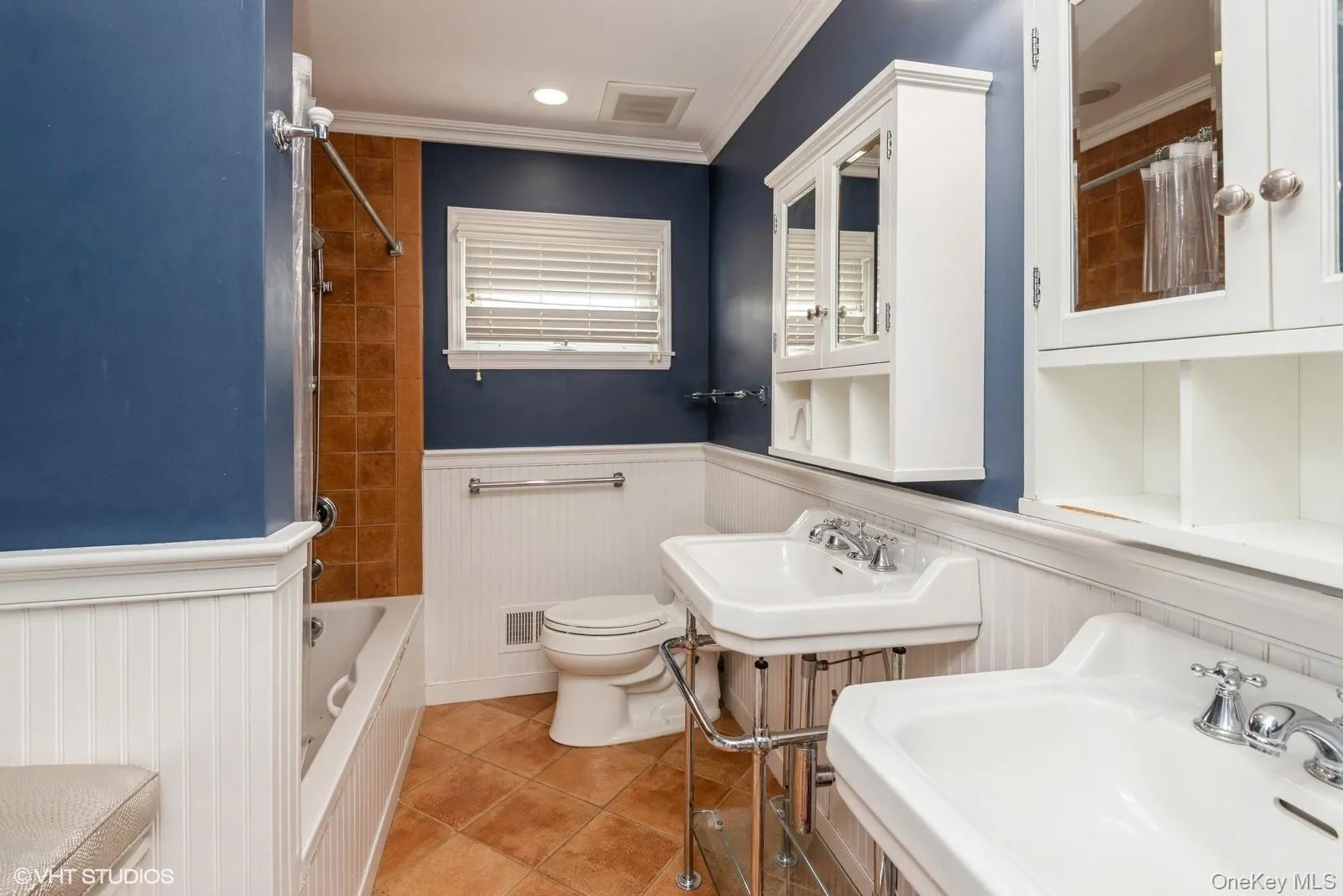 Full bath with shower / tub combo, a wainscoted wall, ornamental molding, light tile patterned floors, and recessed lighting Full bath with shower / tub combo, a wainscoted wall, ornamental molding, light tile patterned floors, and recessed lighting