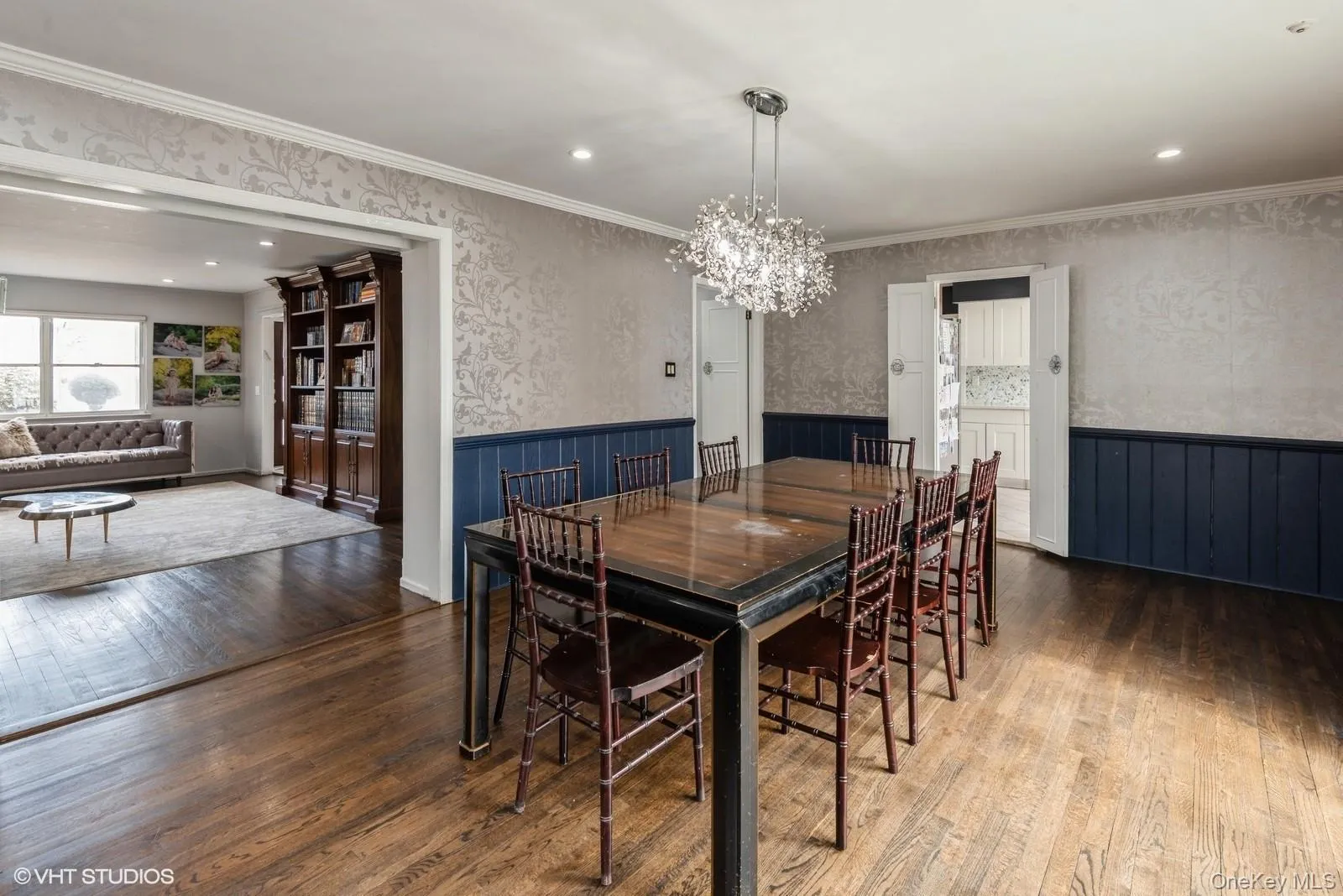Dining room featuring a chandelier, wallpapered walls, hardwood / wood-style floors, recessed lighting, and ornamental molding Dining room featuring a chandelier, wallpapered walls, hardwood / wood-style floors, recessed lighting, and ornamental molding