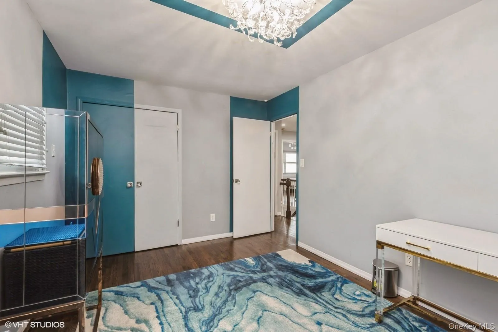 Bedroom featuring dark wood finished floors, a closet, and a chandelier Bedroom featuring dark wood finished floors, a closet, and a chandelier