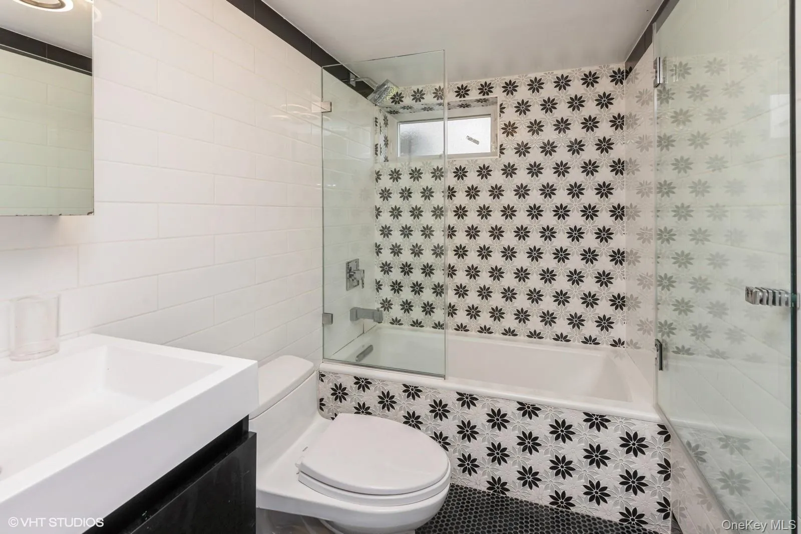 Full bathroom with tile walls, tiled shower / bath, and vanity Full bathroom with tile walls, tiled shower / bath, and vanity