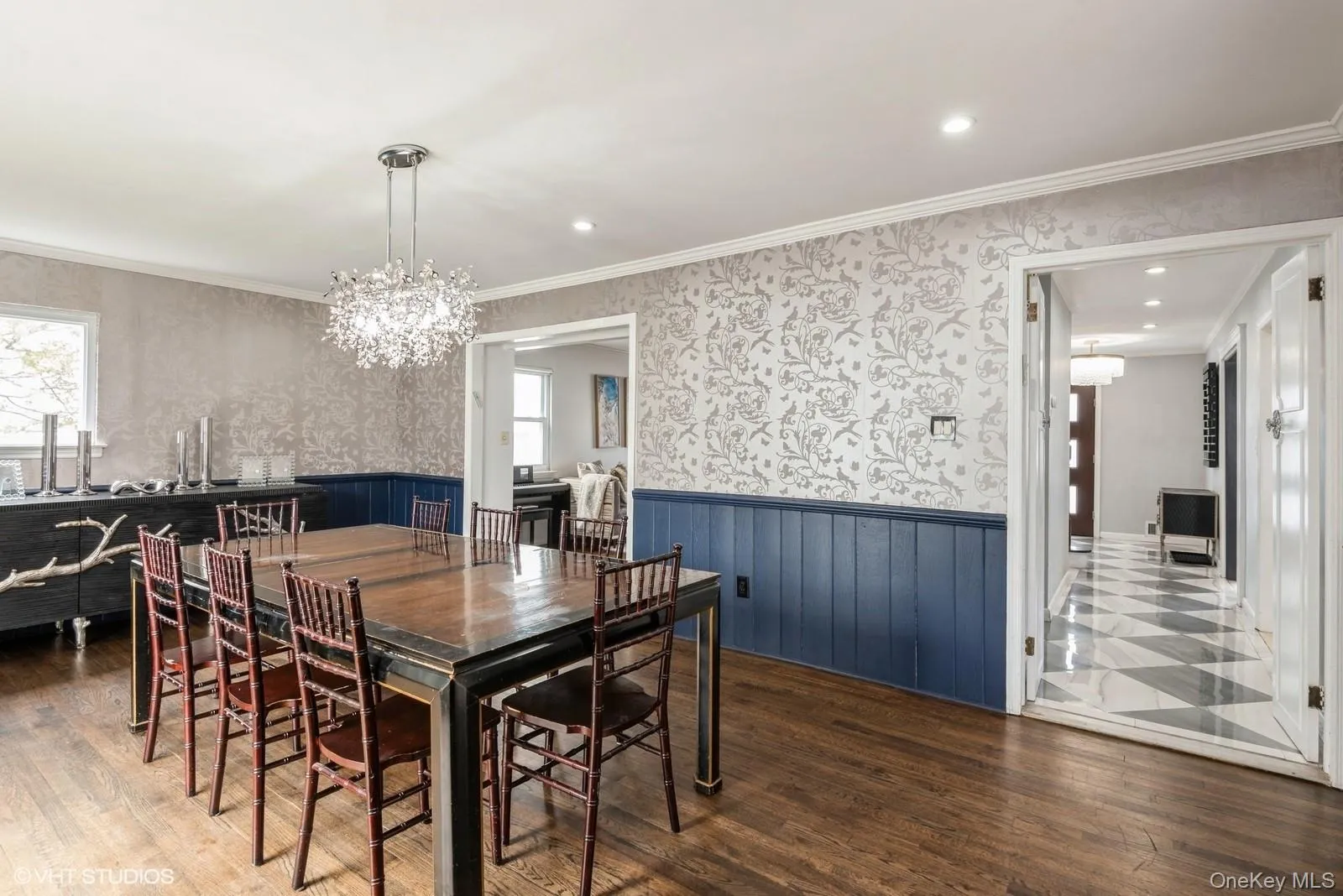Dining area featuring wallpapered walls, wood finished floors, recessed lighting, ornamental molding, and a chandelier Dining area featuring wallpapered walls, wood finished floors, recessed lighting, ornamental molding, and a chandelier