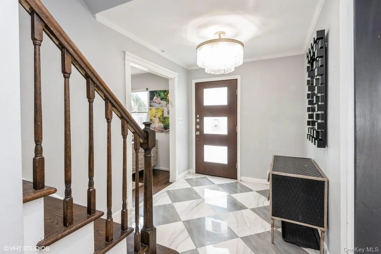 Entrance foyer with crown molding, a chandelier, and stairway Entrance foyer with crown molding, a chandelier, and stairway
