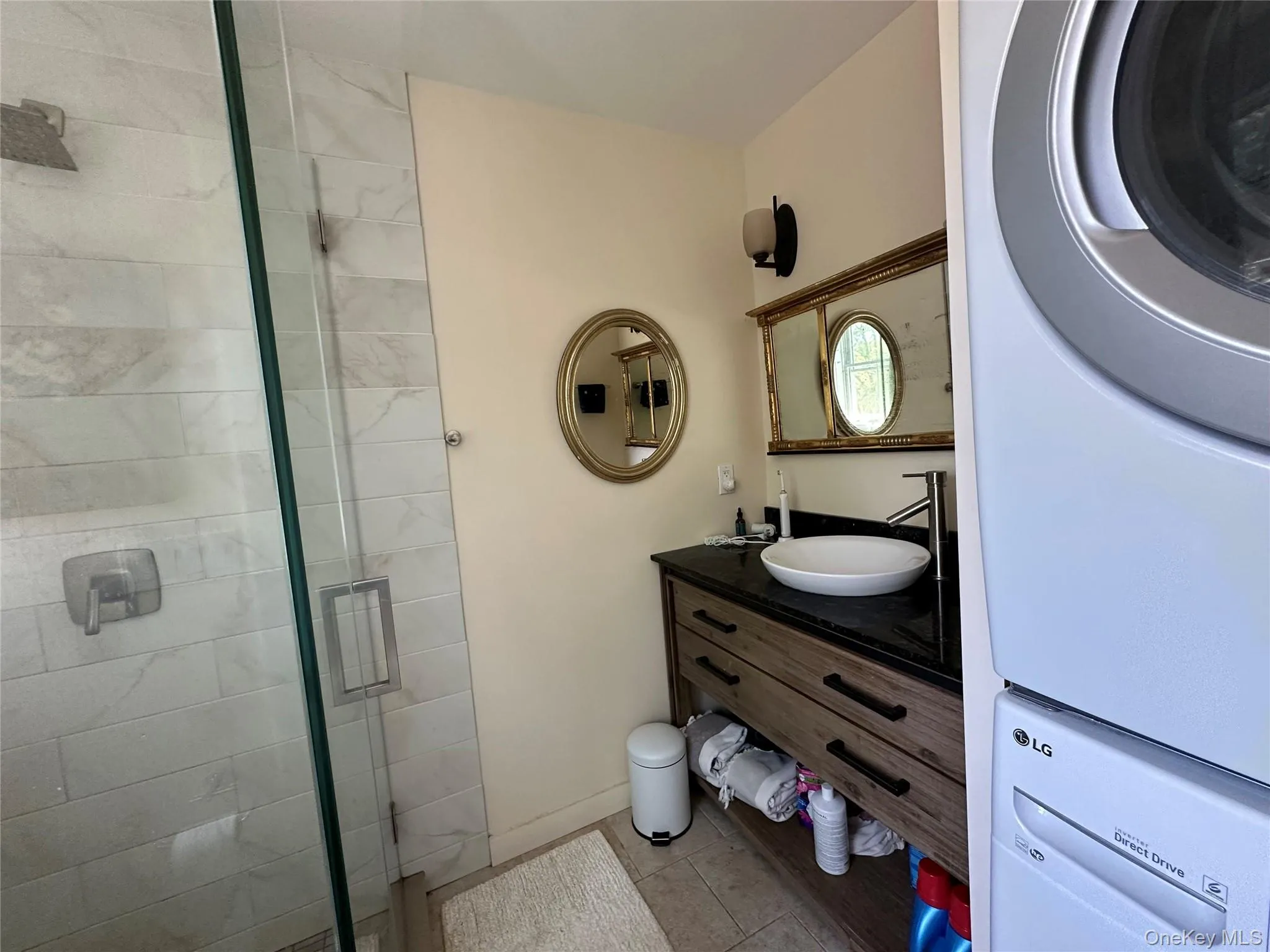 Bathroom featuring a stall shower, vanity, and tile patterned floors Bathroom featuring a stall shower, vanity, and tile patterned floors