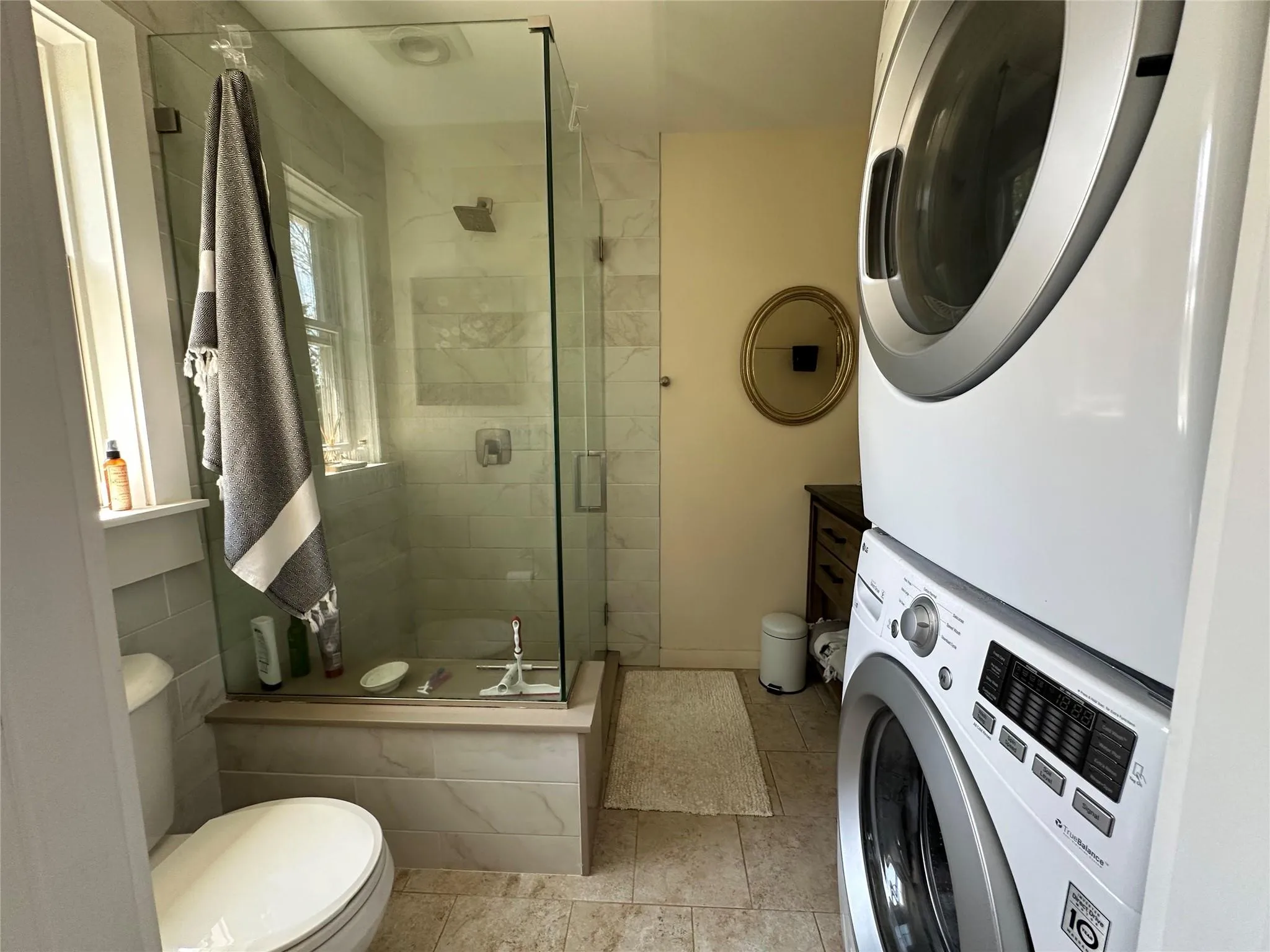 Bathroom with stacked washer / drying machine and a stall shower Bathroom with stacked washer / drying machine and a stall shower