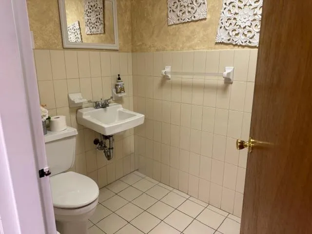 Bathroom with tile walls and a wainscoted wall Bathroom with tile walls and a wainscoted wall