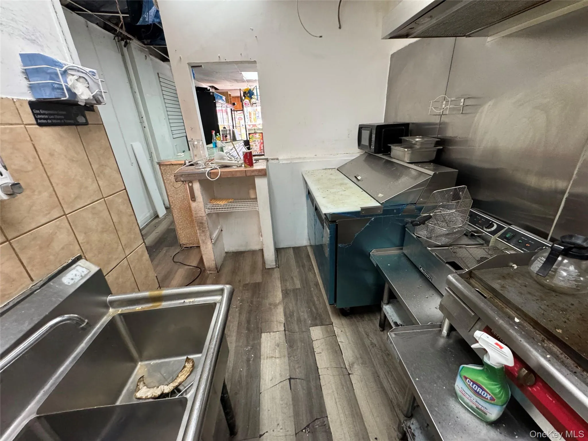 Kitchen with wood finished floors, black microwave, and extractor fan Kitchen with wood finished floors, black microwave, and extractor fan