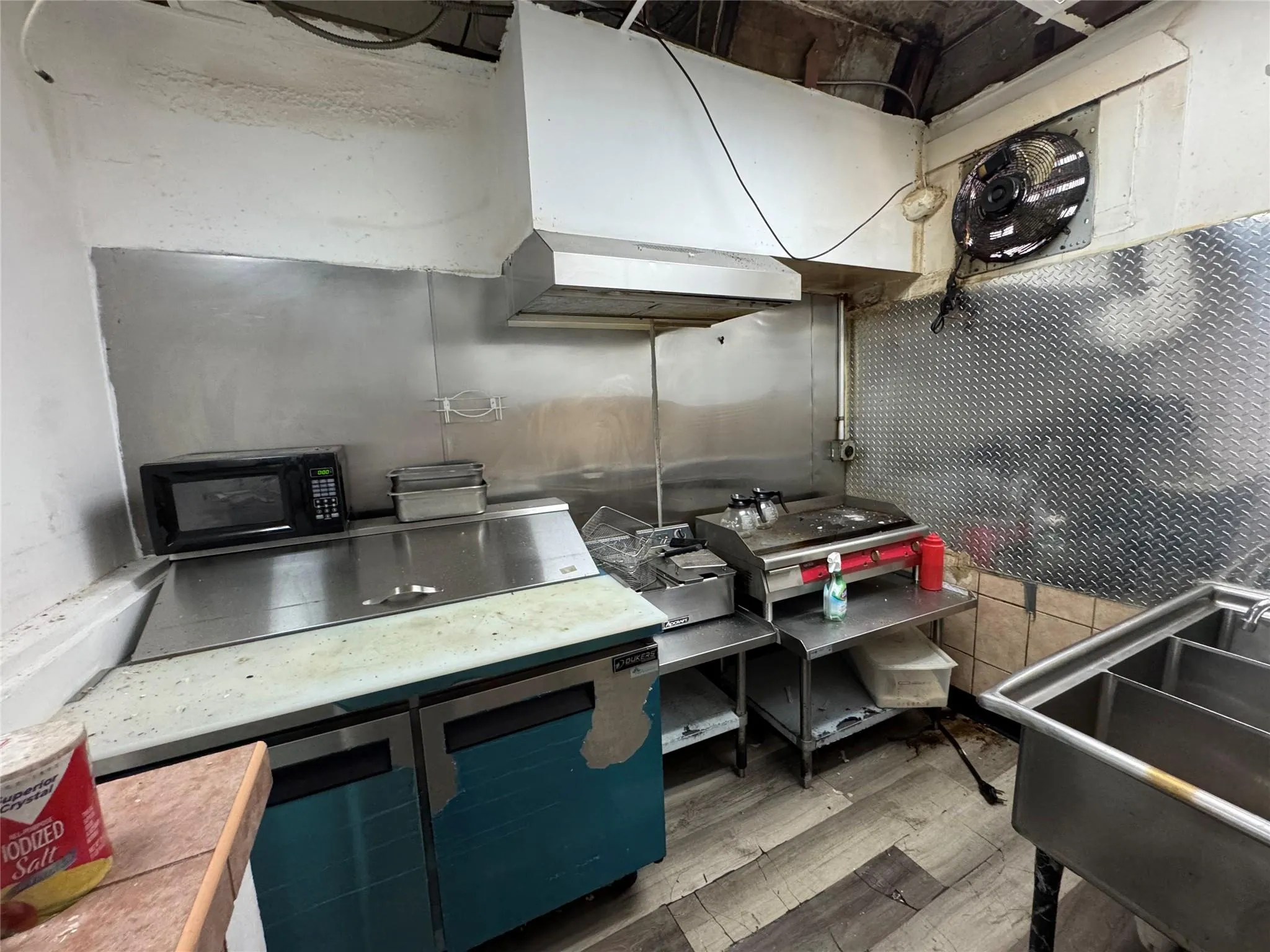 Kitchen with black microwave, wood finished floors, and ventilation hood Kitchen with black microwave, wood finished floors, and ventilation hood
