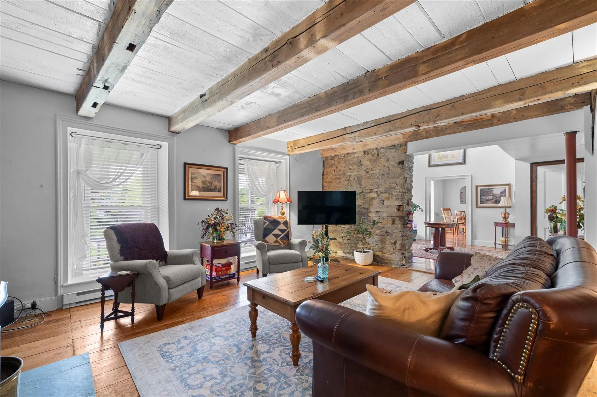 Living area featuring hardwood / wood-style floors, a wood ceiling with exposed beams, a baseboard heating unit, and baseboard heating Living area featuring hardwood / wood-style floors, a wood ceiling with exposed beams, a baseboard heating unit, and baseboard heating