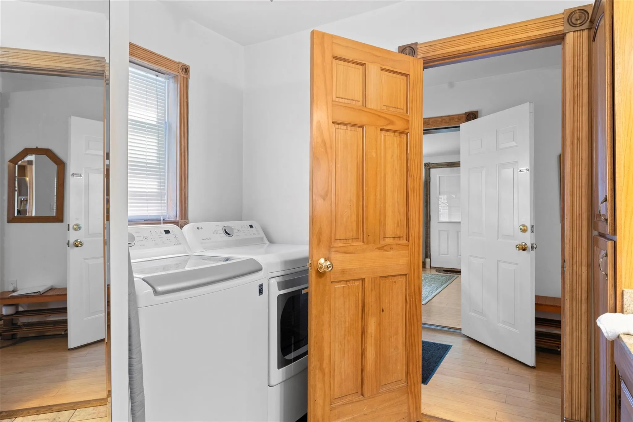 Washroom with washer and clothes dryer and light wood finished floors Washroom with washer and clothes dryer and light wood finished floors