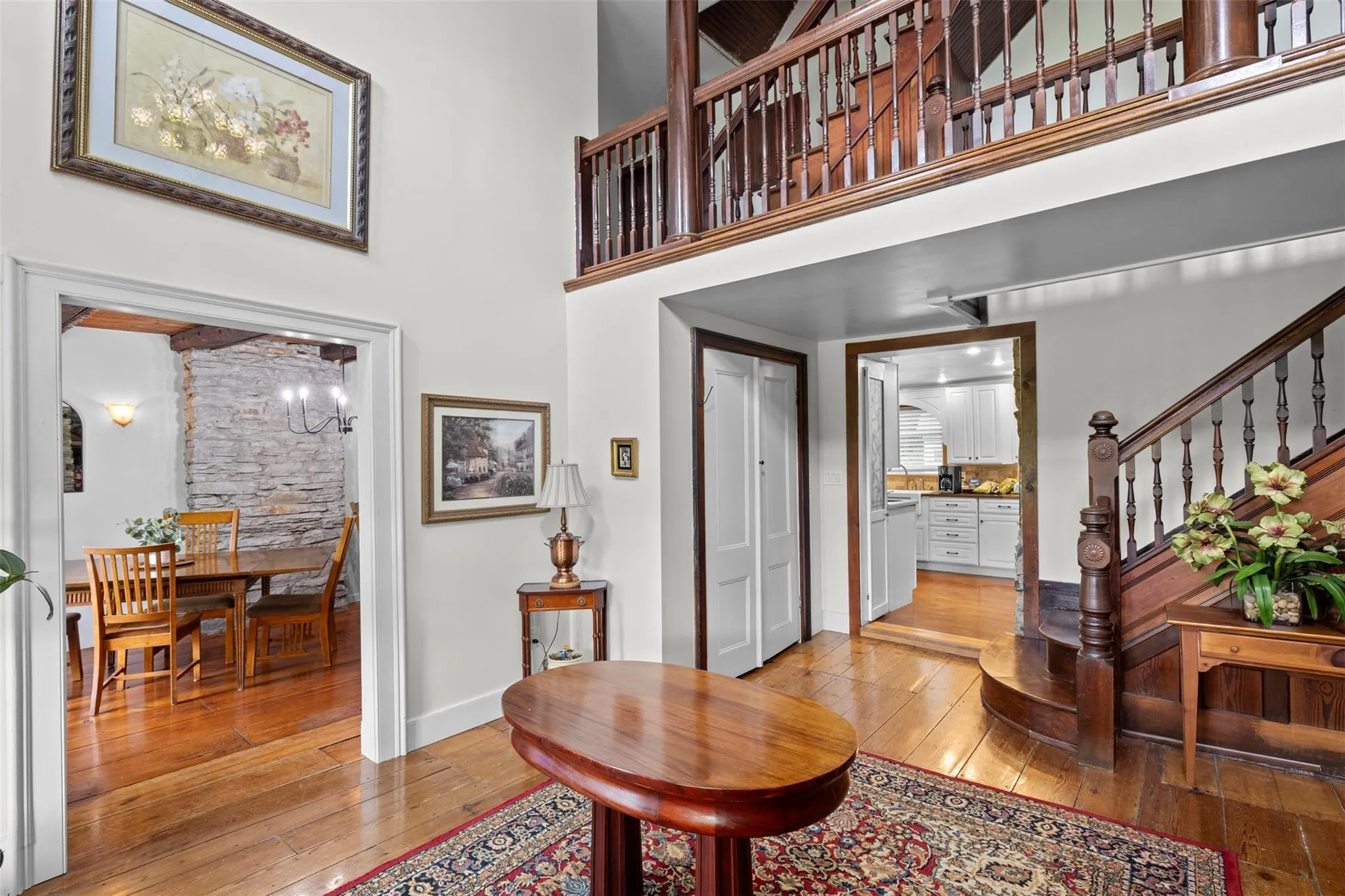 Foyer entrance with light wood-type flooring, a towering ceiling, and stairs Foyer entrance with light wood-type flooring, a towering ceiling, and stairs