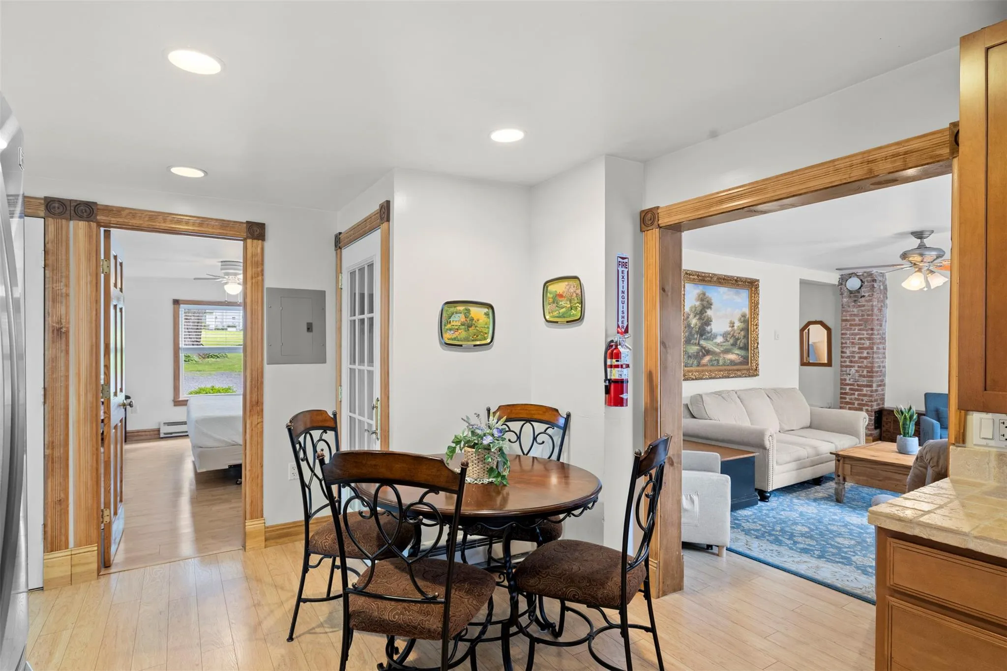 Dining room featuring ceiling fan, electric panel, light wood-type flooring, baseboard heating, and recessed lighting Dining room featuring ceiling fan, electric panel, light wood-type flooring, baseboard heating, and recessed lighting