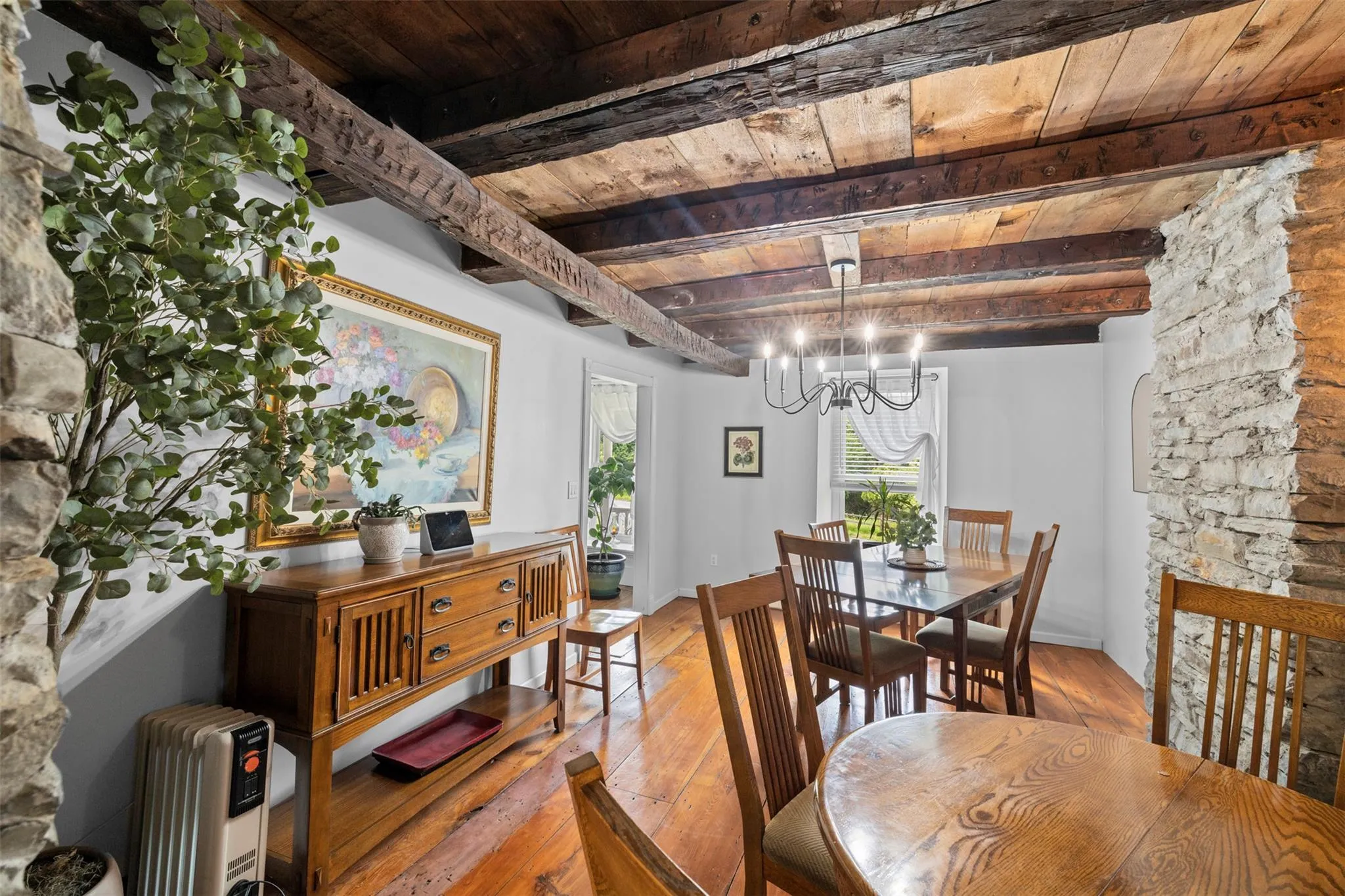 Dining room featuring a wood ceiling with exposed beams, a chandelier, and light wood-style floors Dining room featuring a wood ceiling with exposed beams, a chandelier, and light wood-style floors