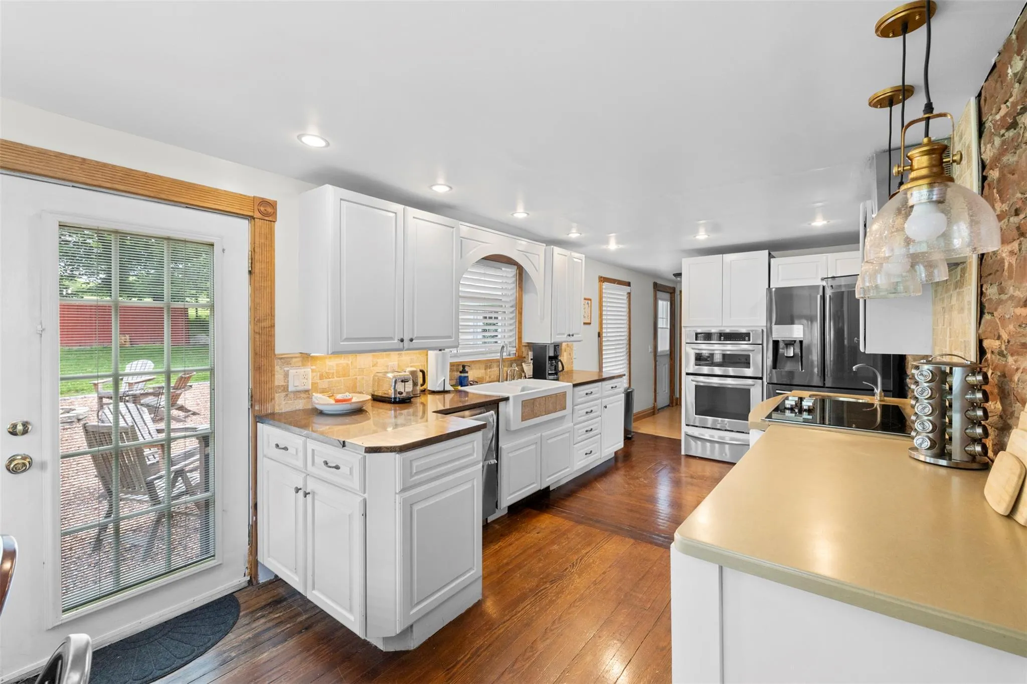 Kitchen featuring appliances with stainless steel finishes, tasteful backsplash, white cabinets, a warming drawer, and recessed lighting Kitchen featuring appliances with stainless steel finishes, tasteful backsplash, white cabinets, a warming drawer, and recessed lighting