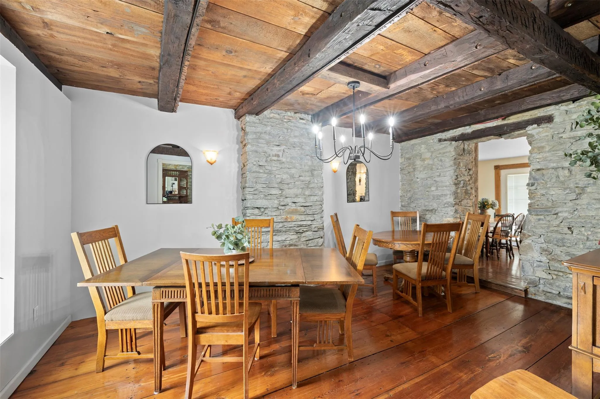 Dining space with a wood ceiling with exposed beams, hardwood / wood-style flooring, and a chandelier Dining space with a wood ceiling with exposed beams, hardwood / wood-style flooring, and a chandelier