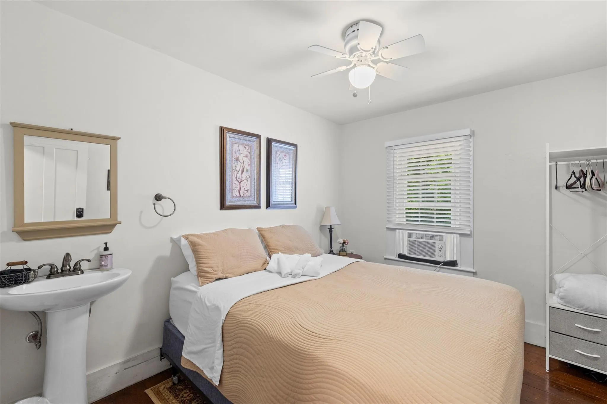 Bedroom featuring cooling unit, dark wood-type flooring, and a ceiling fan Bedroom featuring cooling unit, dark wood-type flooring, and a ceiling fan