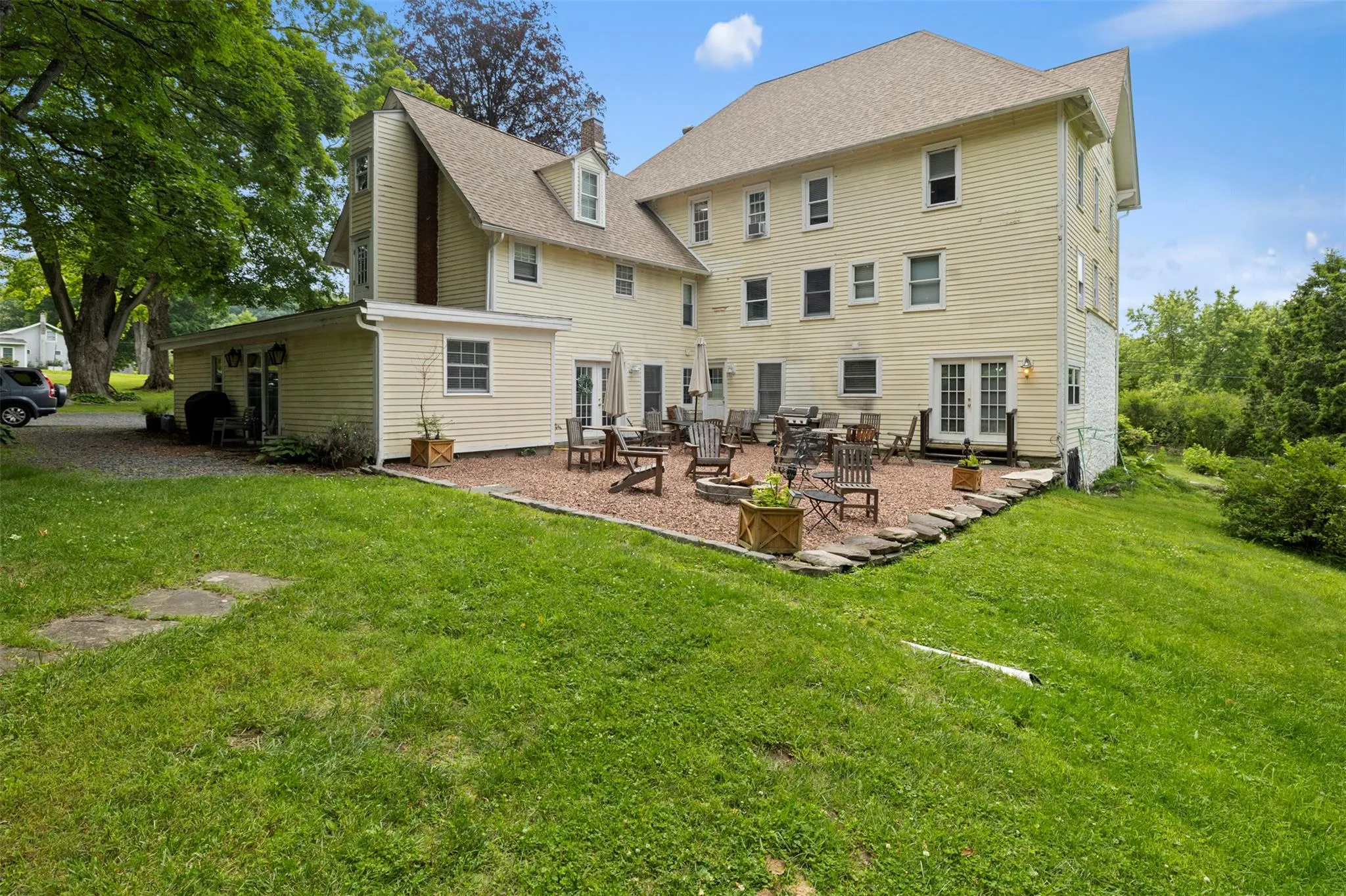 Rear view of house with a lawn, french doors, a patio area, and roof with shingles Rear view of house with a lawn, french doors, a patio area, and roof with shingles