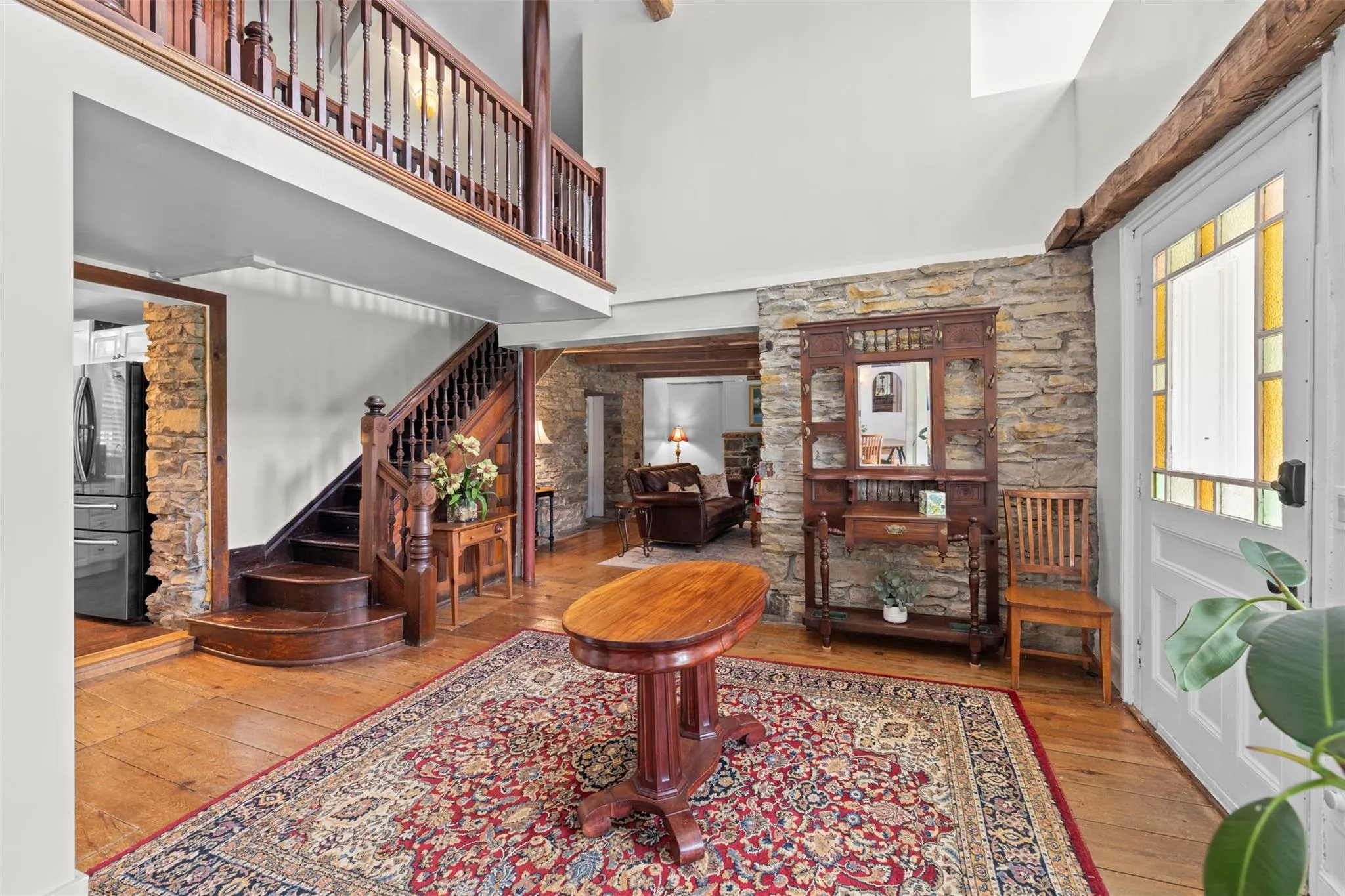 Foyer entrance with hardwood / wood-style flooring, stairs, and a towering ceiling Foyer entrance with hardwood / wood-style flooring, stairs, and a towering ceiling