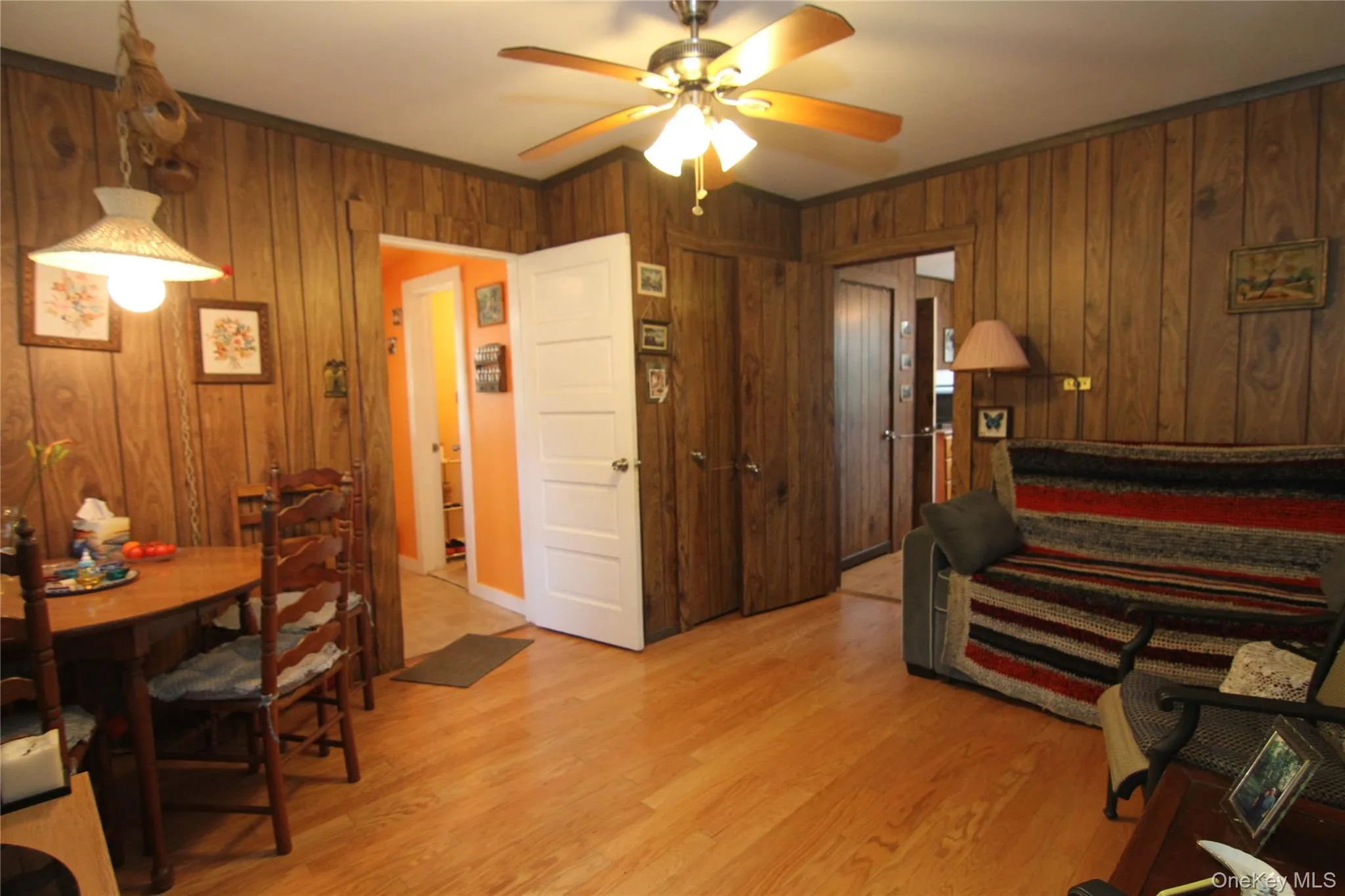 Bedroom with wooden walls, light wood finished floors, ceiling fan, and crown molding Bedroom with wooden walls, light wood finished floors, ceiling fan, and crown molding