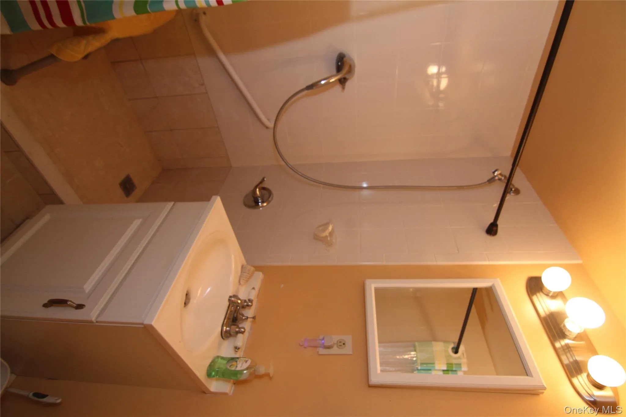 Full bathroom featuring tiled shower, vanity, and tile patterned flooring Full bathroom featuring tiled shower, vanity, and tile patterned flooring