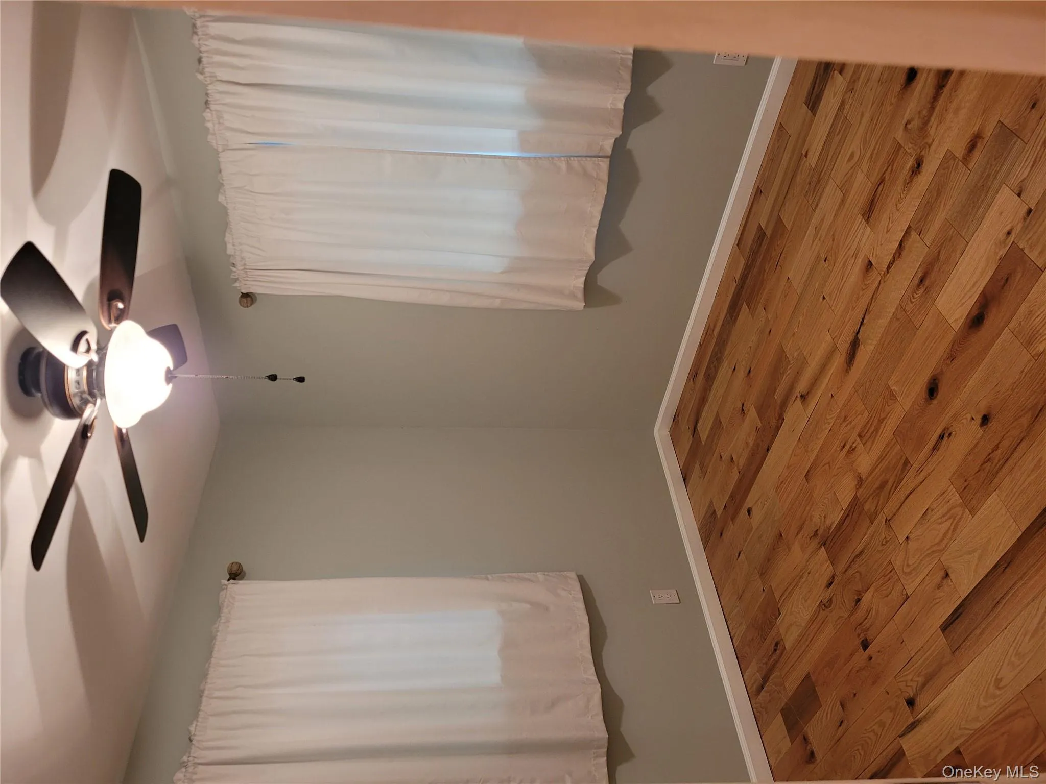 Unfurnished room with ceiling fan and wood finished floors Unfurnished room with ceiling fan and wood finished floors