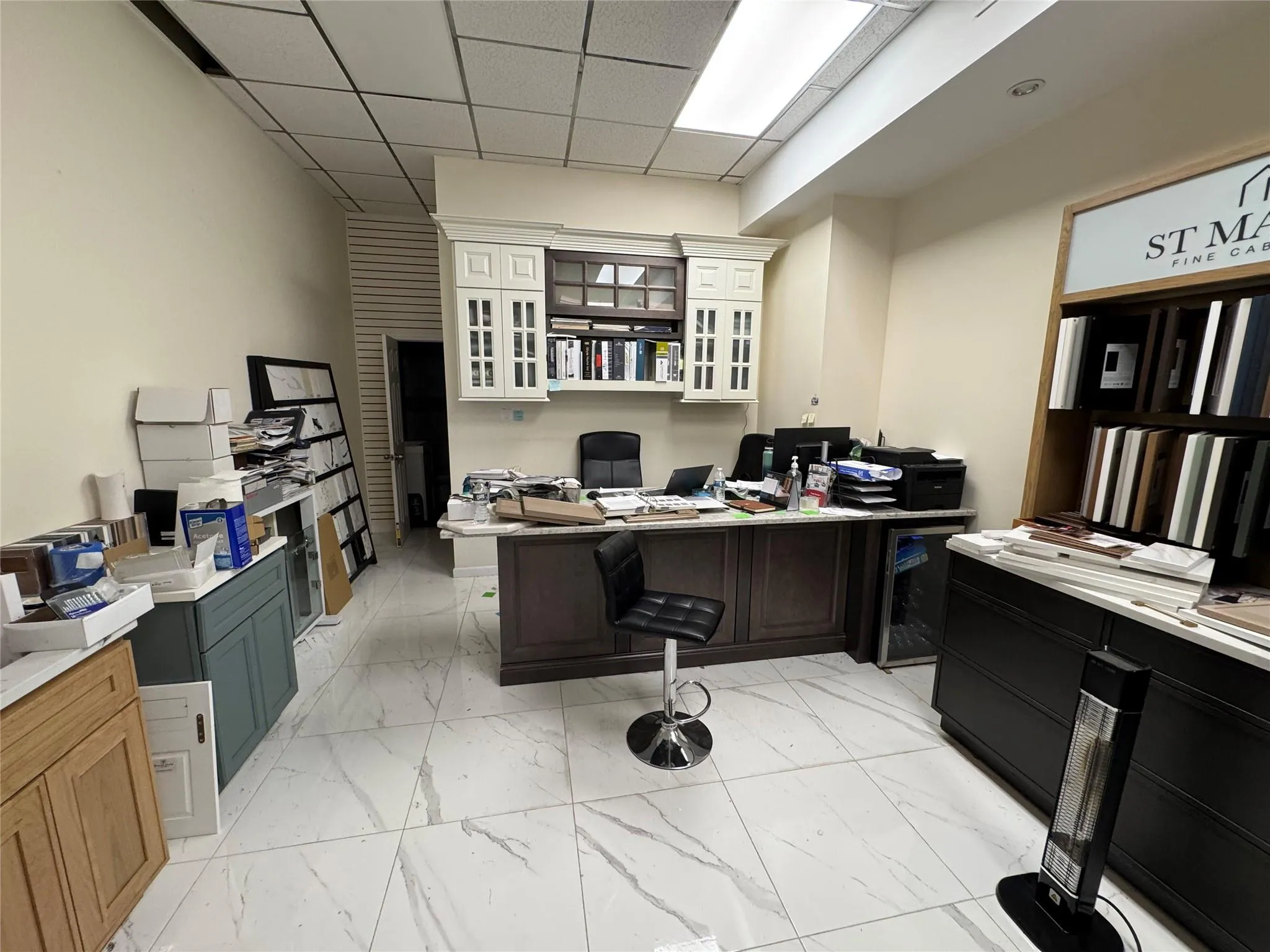 Home office featuring light marble finish flooring, beverage cooler, and a paneled ceiling Home office featuring light marble finish flooring, beverage cooler, and a paneled ceiling