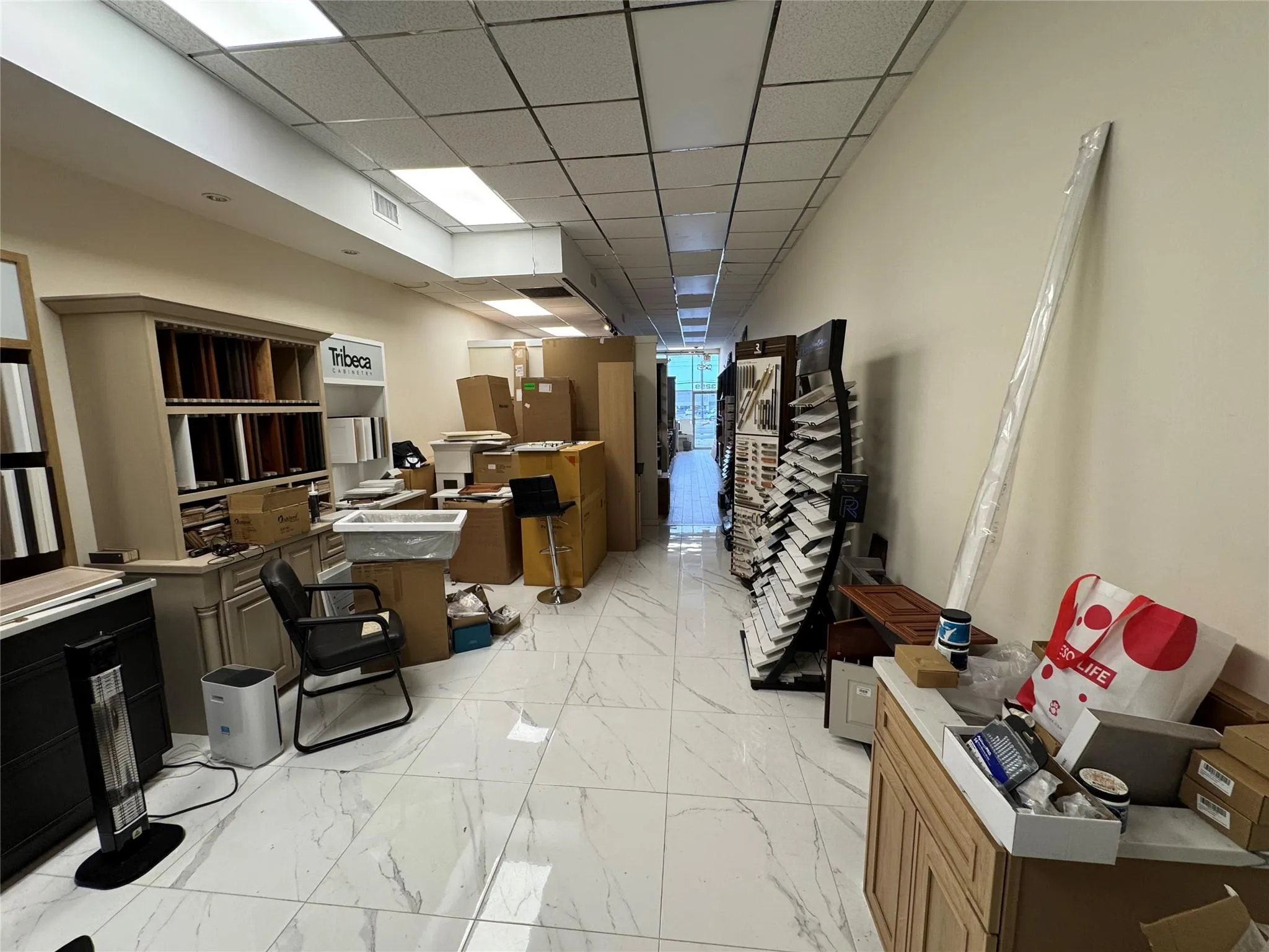 Office space with light marble finish flooring and a paneled ceiling Office space with light marble finish flooring and a paneled ceiling