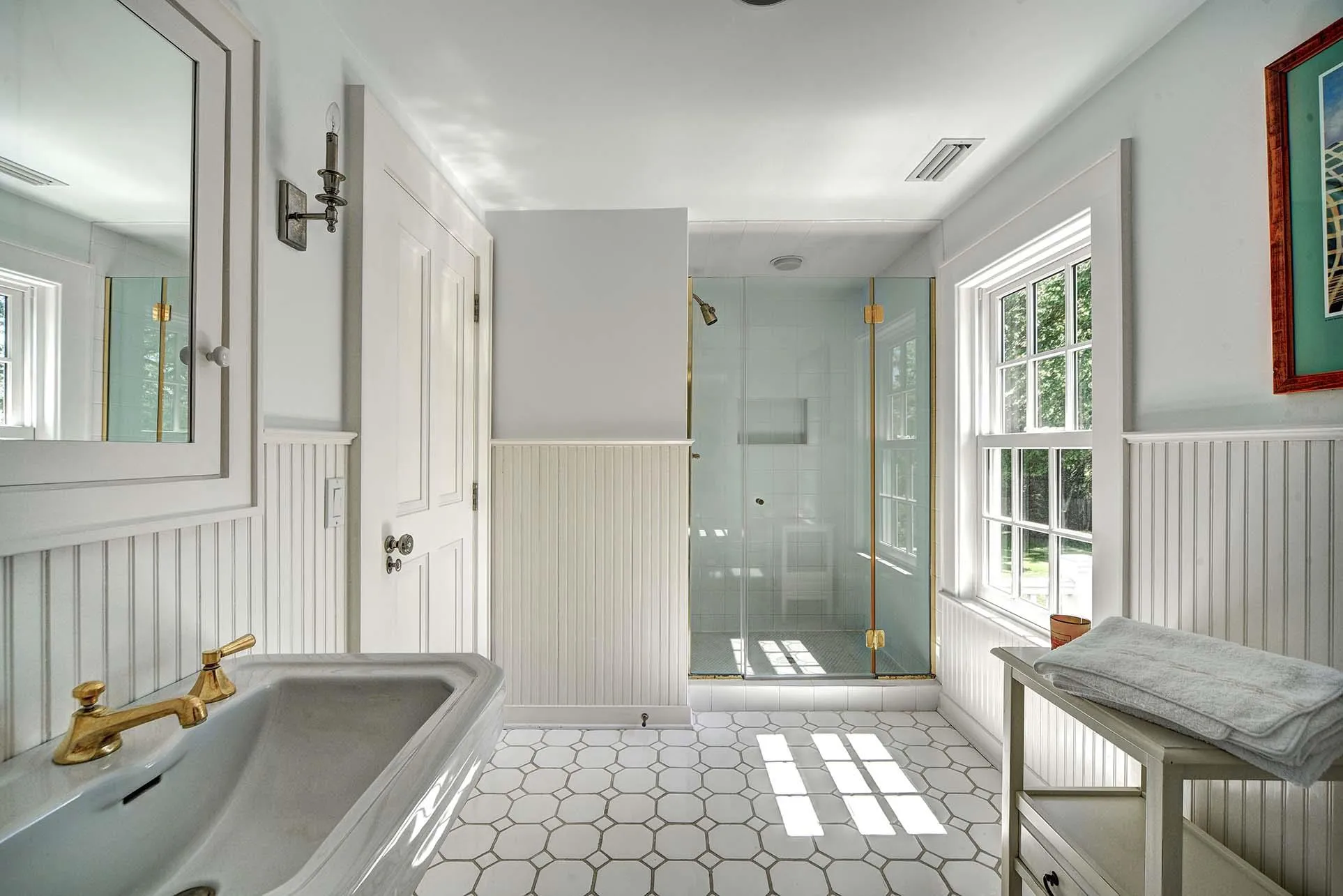 Full bath with a wainscoted wall, a stall shower, and tile patterned floors Full bath with a wainscoted wall, a stall shower, and tile patterned floors