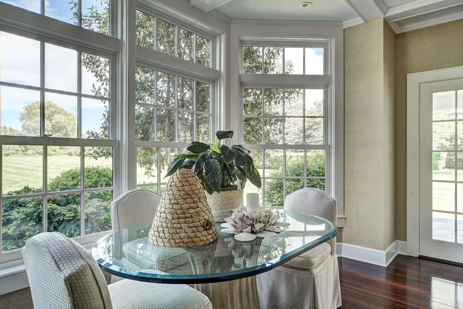 Sunroom featuring wood finished floors, healthy amount of natural light, and crown molding Sunroom featuring wood finished floors, healthy amount of natural light, and crown molding