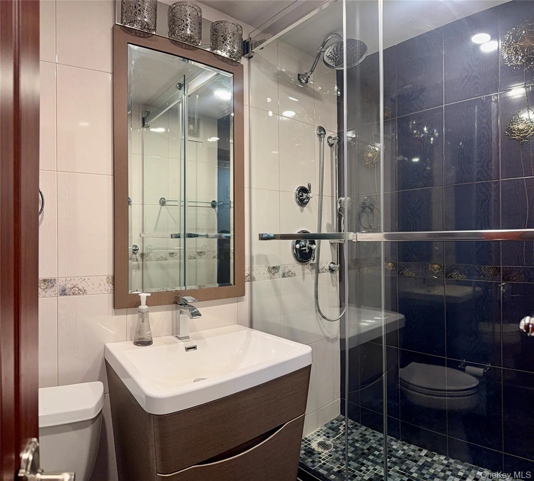 Bathroom with tile walls, a stall shower, and vanity Bathroom with tile walls, a stall shower, and vanity