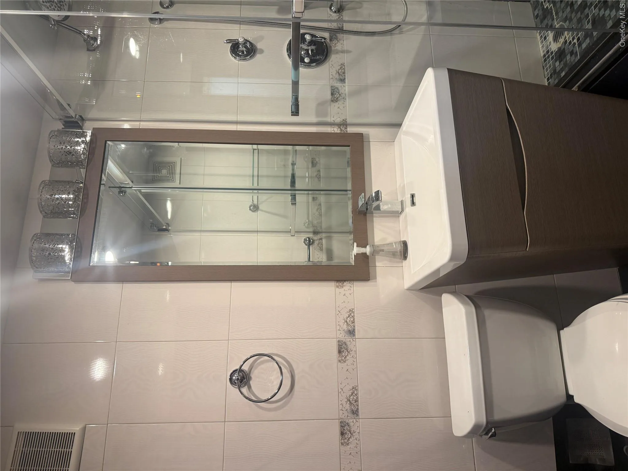 Bathroom featuring tile walls, vanity, and a stall shower Bathroom featuring tile walls, vanity, and a stall shower