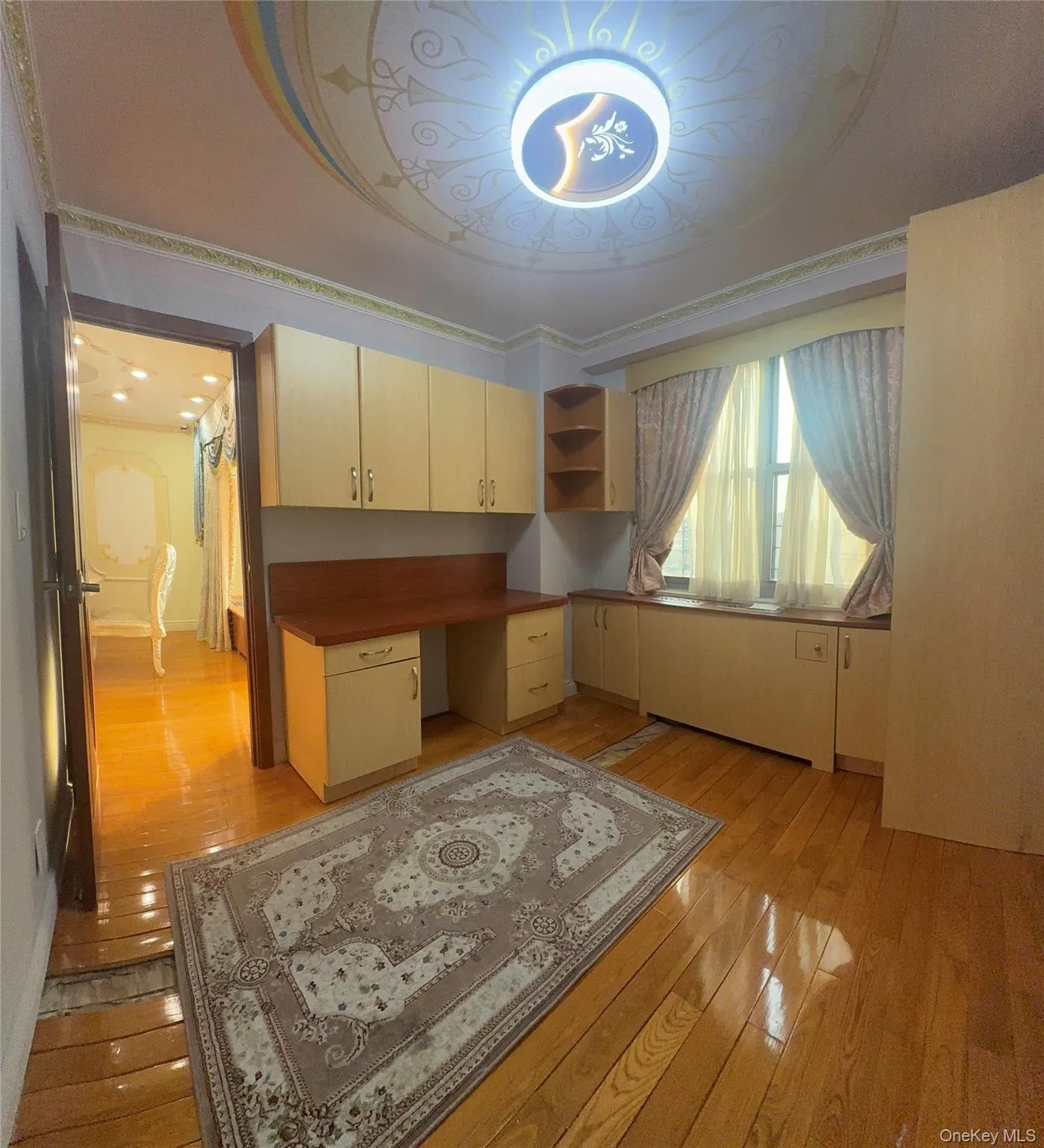 Home office featuring light wood finished floors and built in study area Home office featuring light wood finished floors and built in study area