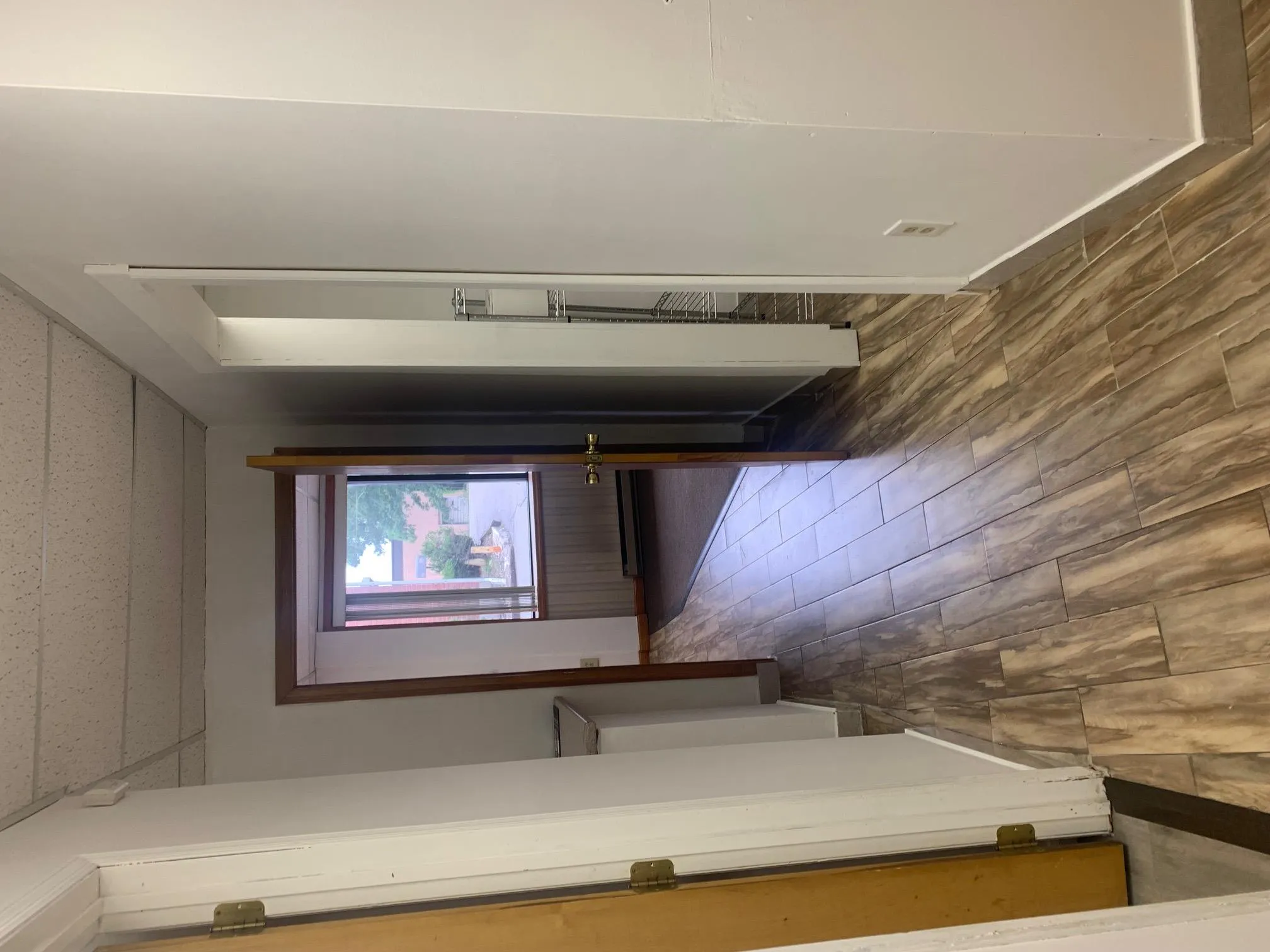 Corridor with a paneled ceiling, wood finished floors, and baseboard heating Corridor with a paneled ceiling, wood finished floors, and baseboard heating