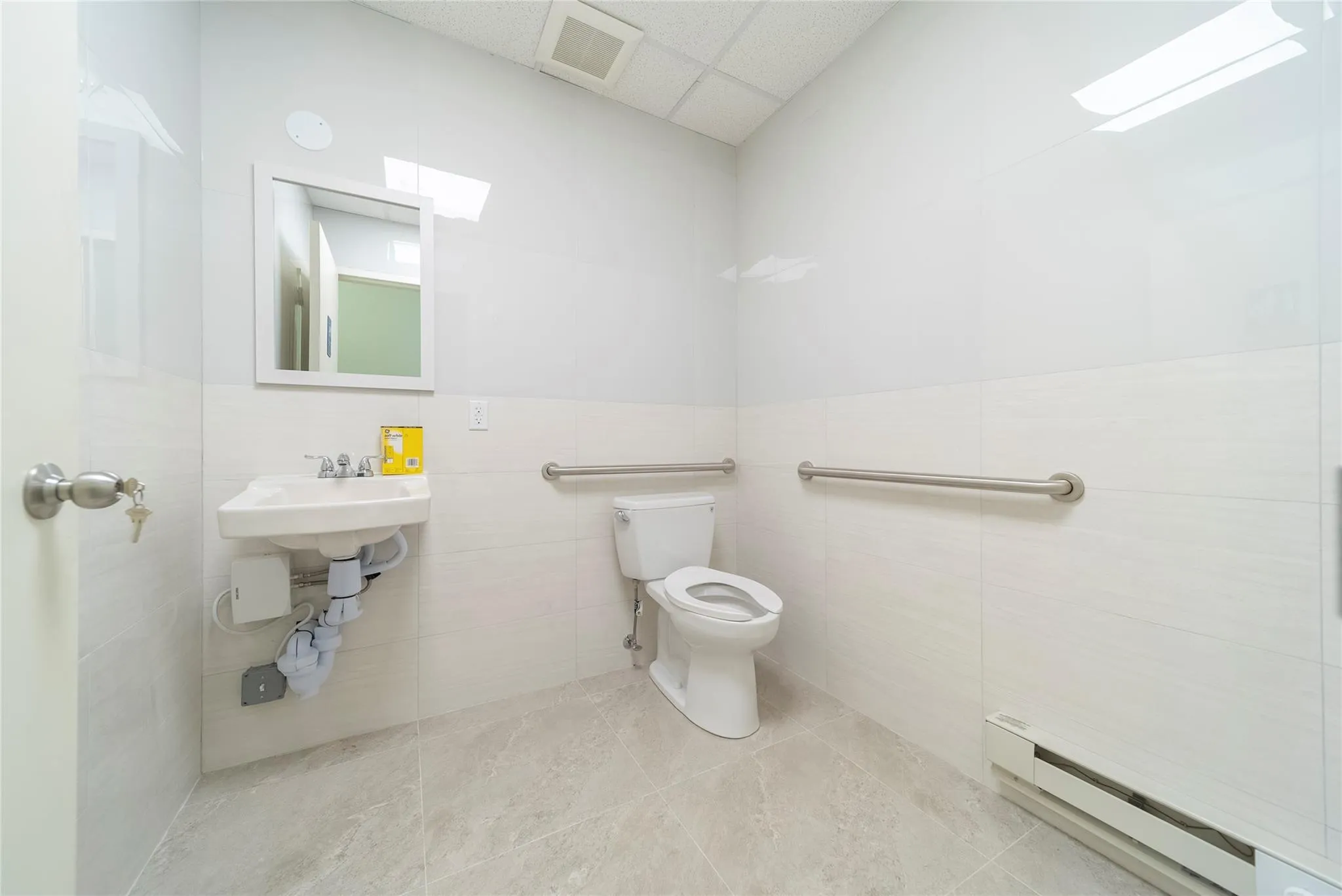 Bathroom featuring a paneled ceiling, tile walls, a baseboard heating unit, tile patterned floors, and toilet Bathroom featuring a paneled ceiling, tile walls, a baseboard heating unit, tile patterned floors, and toilet