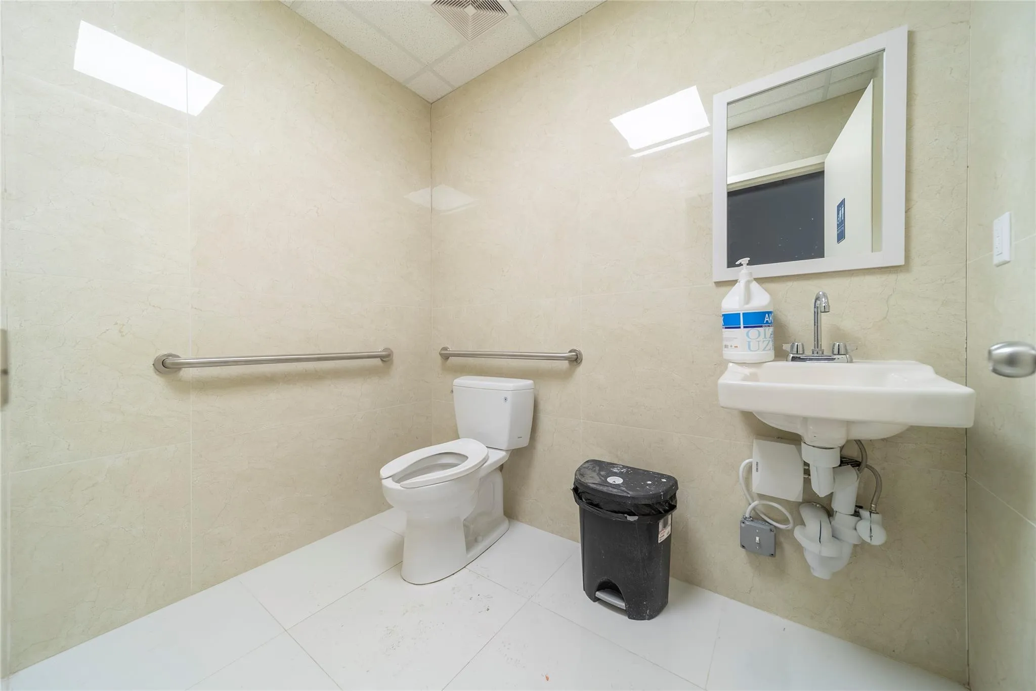 Bathroom with tile patterned flooring, tile walls, and toilet Bathroom with tile patterned flooring, tile walls, and toilet